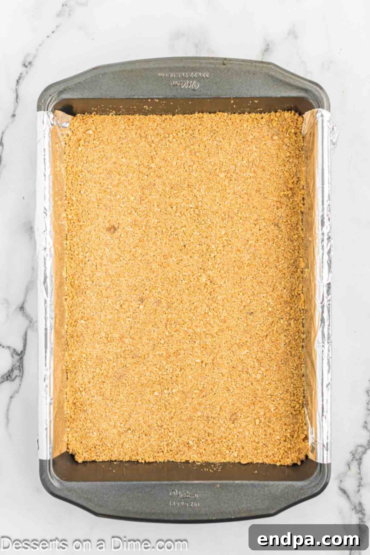 Gooey S'mores Delights 5 Graham cracker crumbs pressed into a baking dish, forming an even crust.