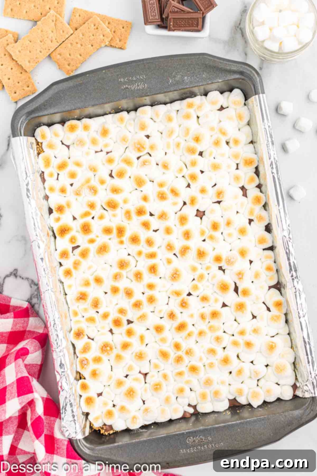 Gooey S'mores Delights 9 S'mores Bars in the pan, cooling down after being broiled.