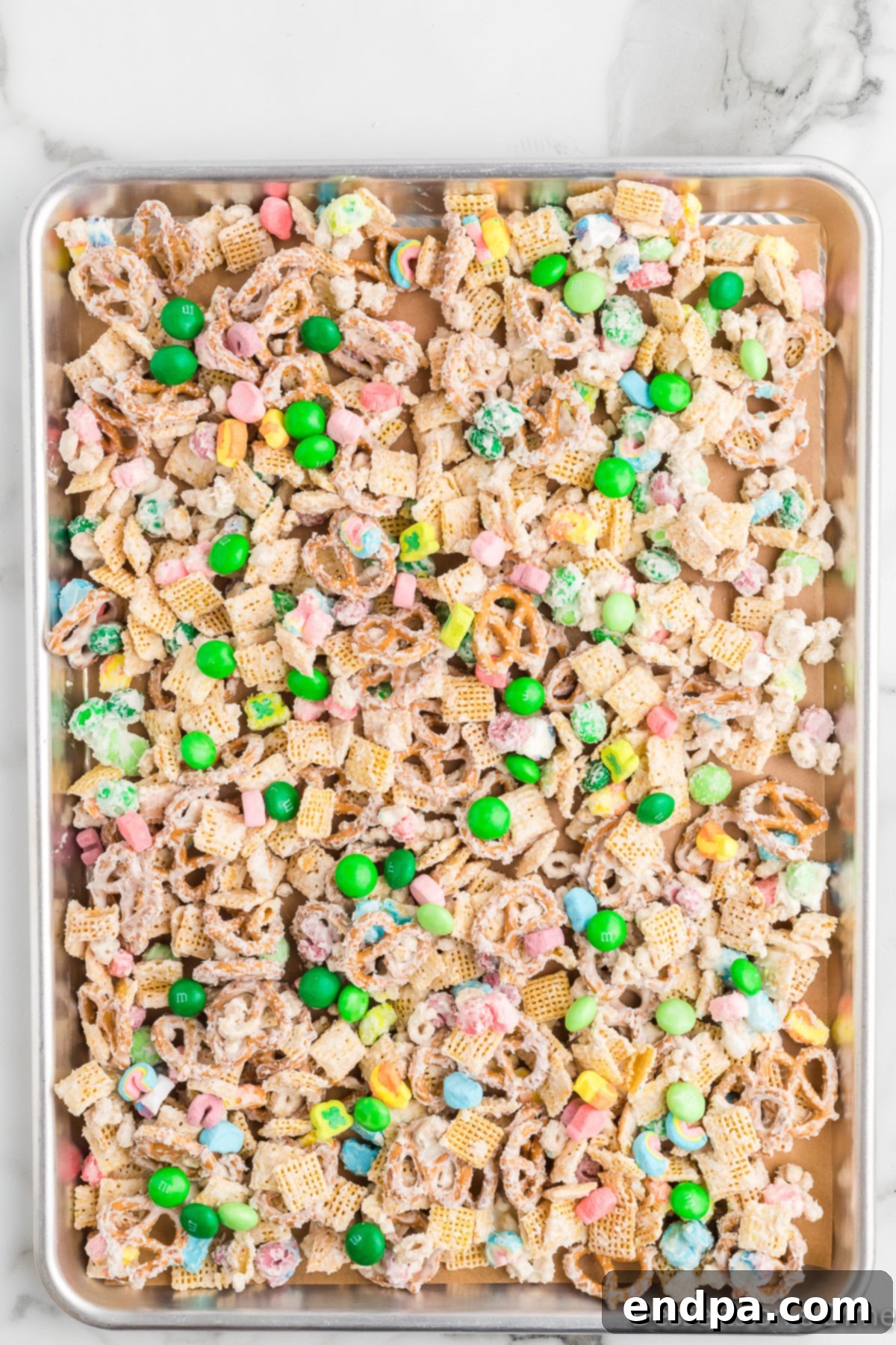 The Leprechaun's Lure 7 The chocolate-coated cereal mixture spread evenly on a baking sheet lined with parchment paper, topped with remaining M&Ms and marshmallows.