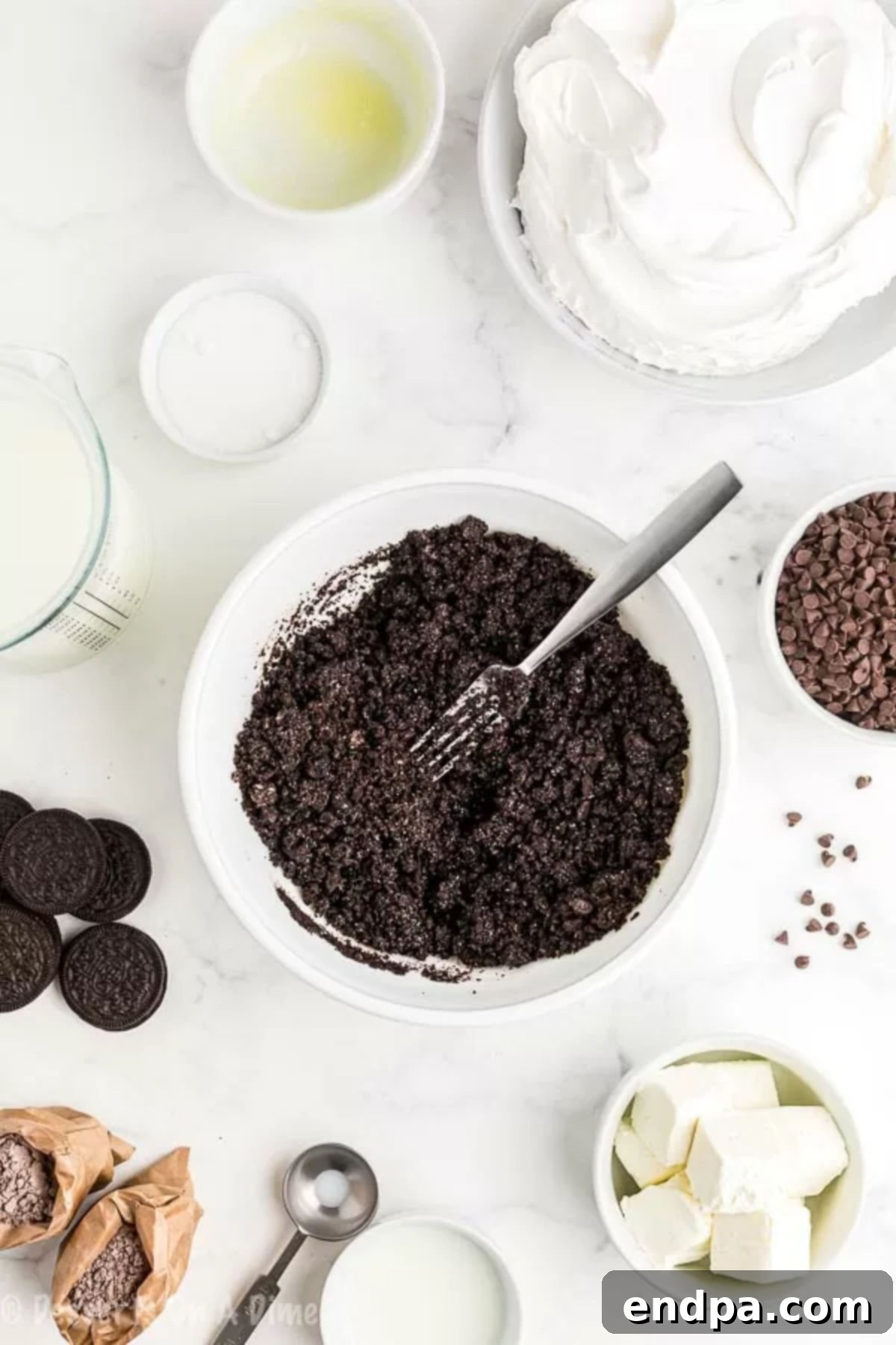Crushed Oreo cookies in a bowl with melted butter. 