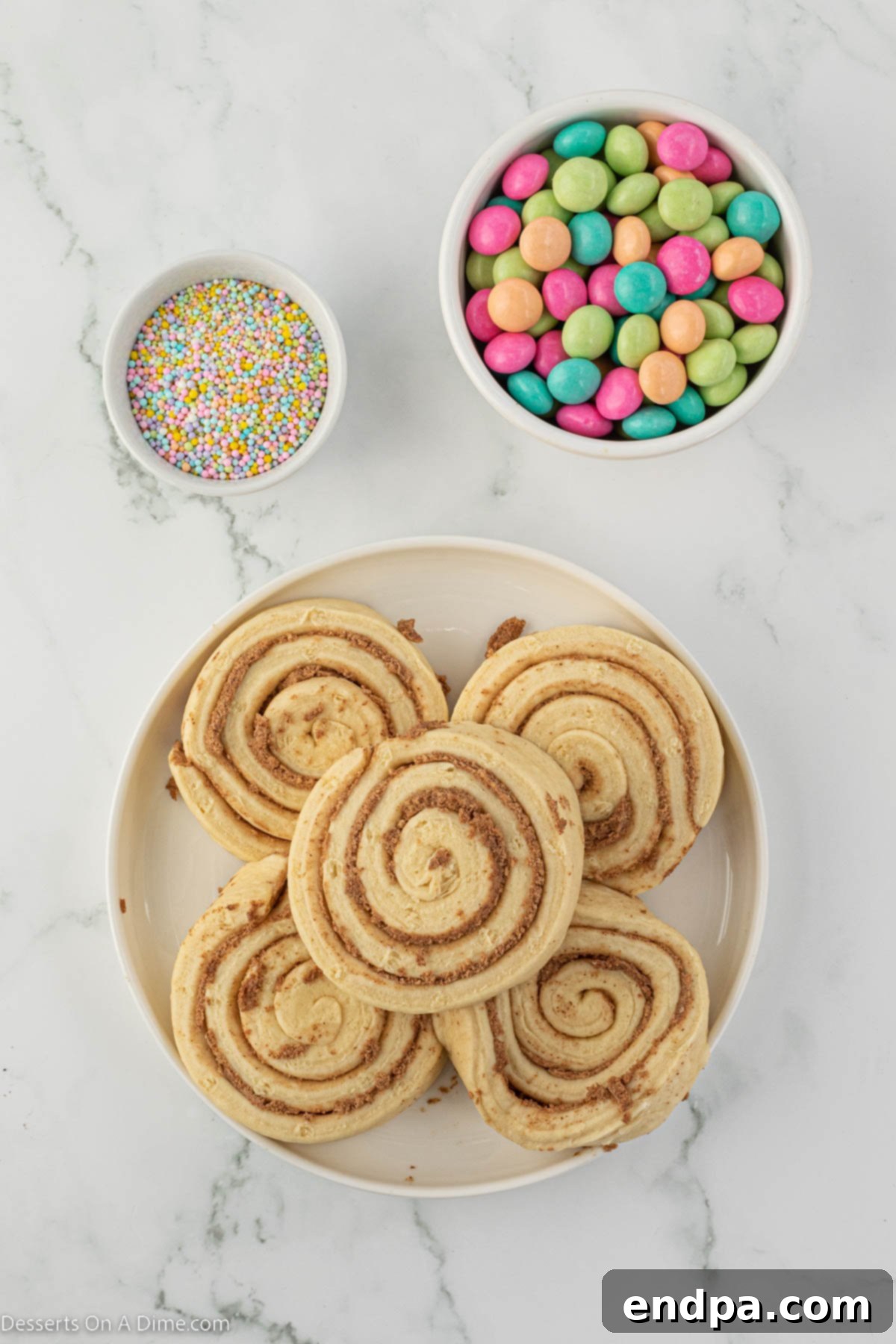 Ingredients for Easter Bunny Cinnamon Rolls including a can of cinnamon rolls, pastel sprinkles, and M&Ms.
