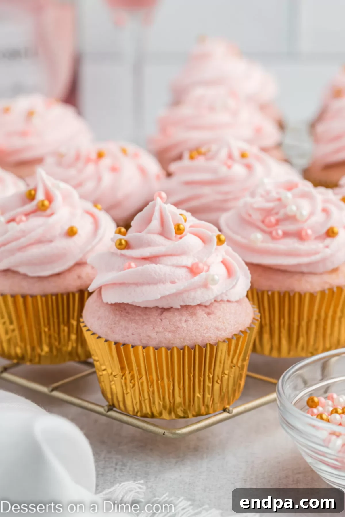 Exquisitely decorated Pink Champagne Cupcakes resting on a cooling rack, awaiting their moment to shine.