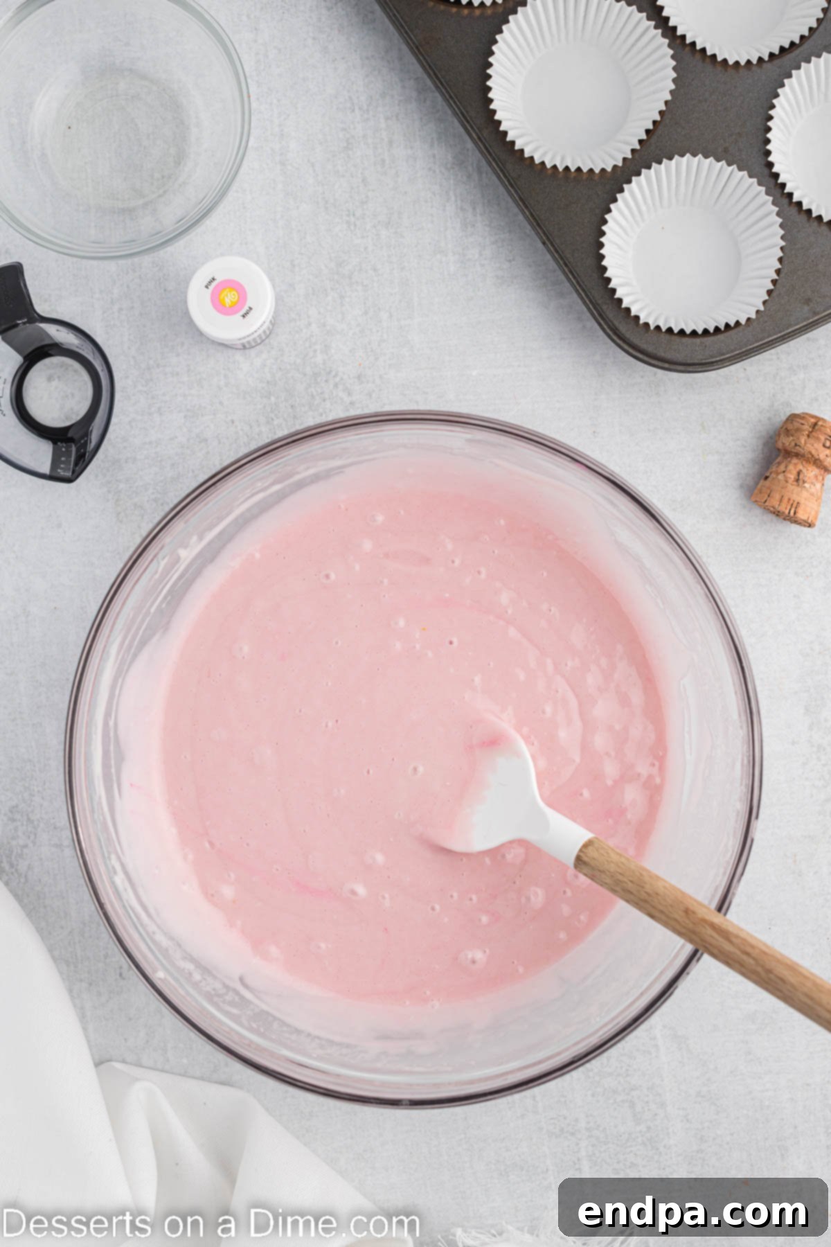 A large mixing bowl containing the light pink cupcake batter, perfectly smooth and ready for the muffin tins.