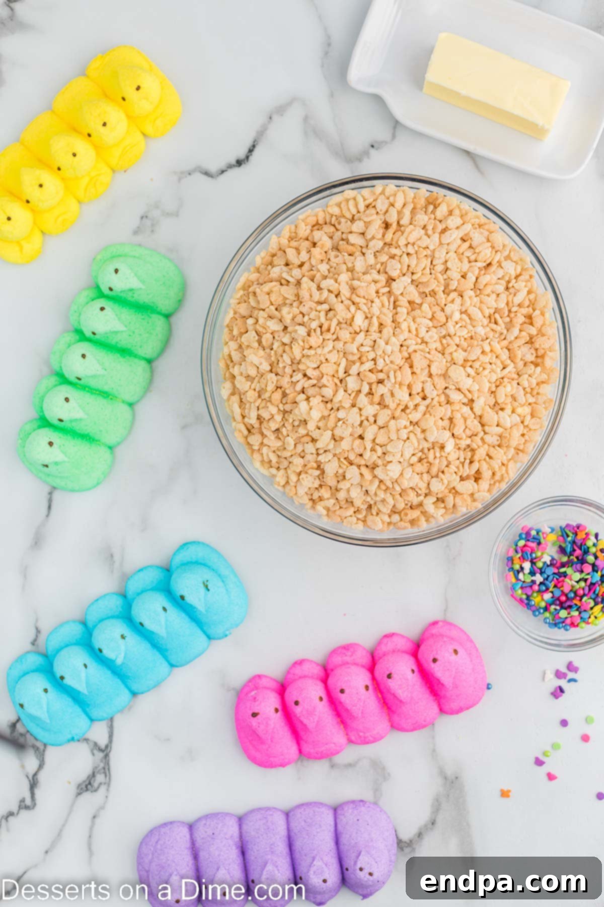 Ingredients needed - Rice Krispie Cereal, Peeps, butter, sprinkles laid out on a white surface.