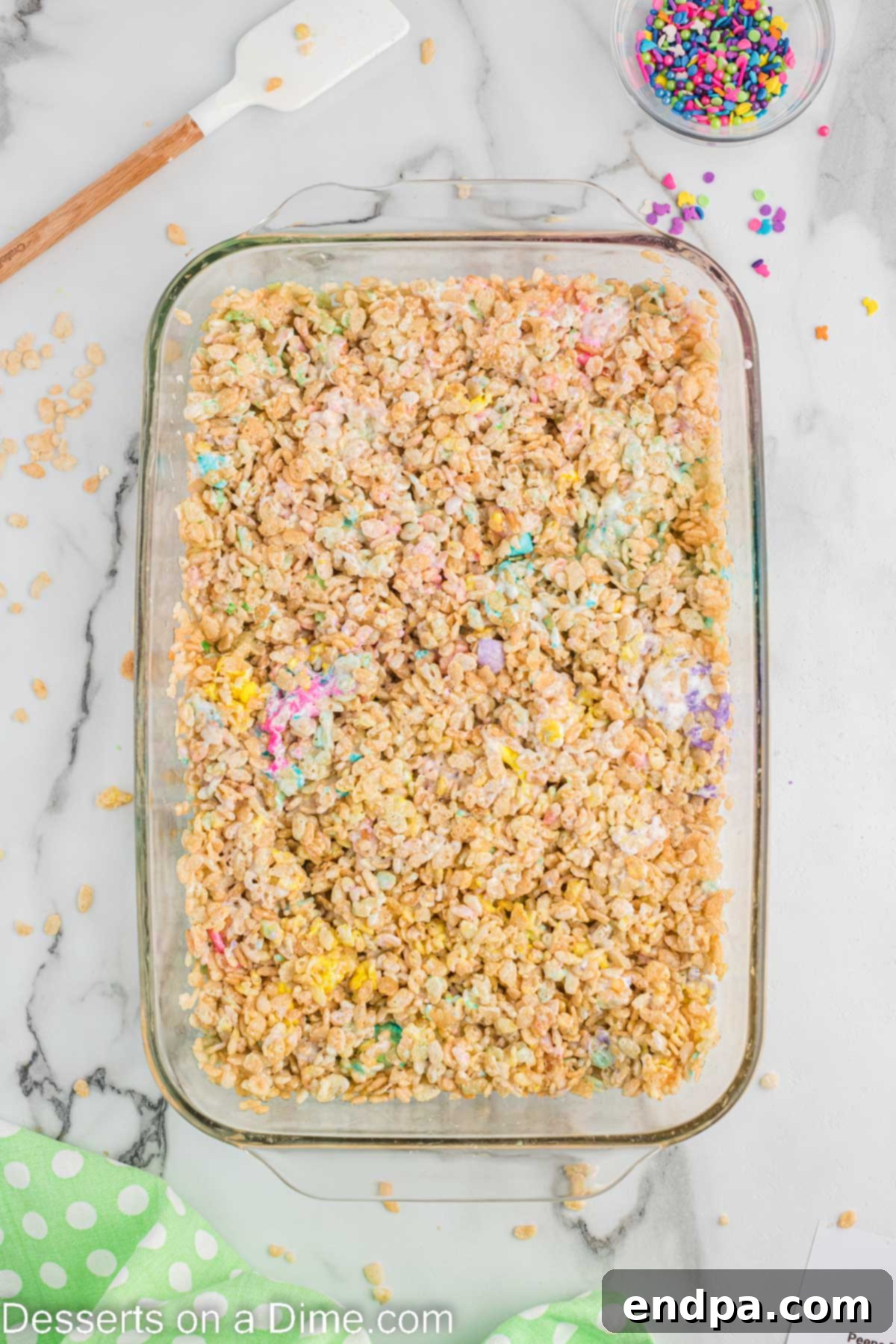 The cereal mixture firmly pressed into an even layer in the baking dish using wax paper.