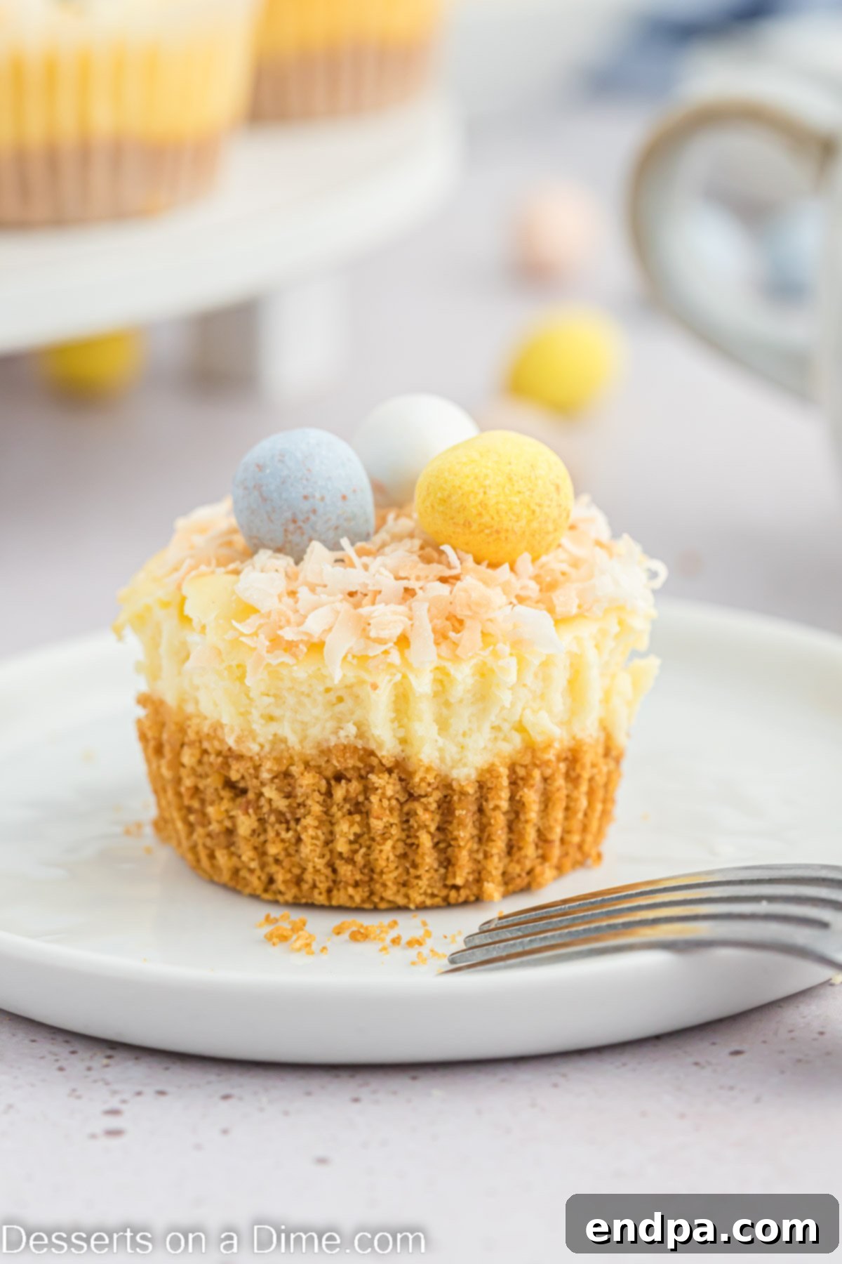 Hoppy Easter Cheesecake Bites 12 A close-up of two Mini Easter Cheesecakes on a platter, showing the detail of the toasted coconut and robin eggs.