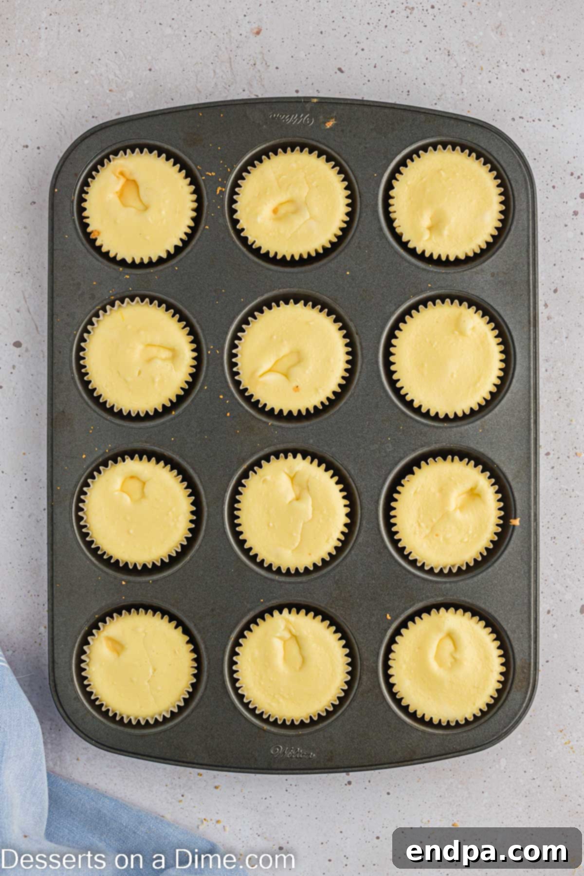 Hoppy Easter Cheesecake Bites 8 A muffin tin filled with baked mini cheesecakes, cooling after being removed from the oven.