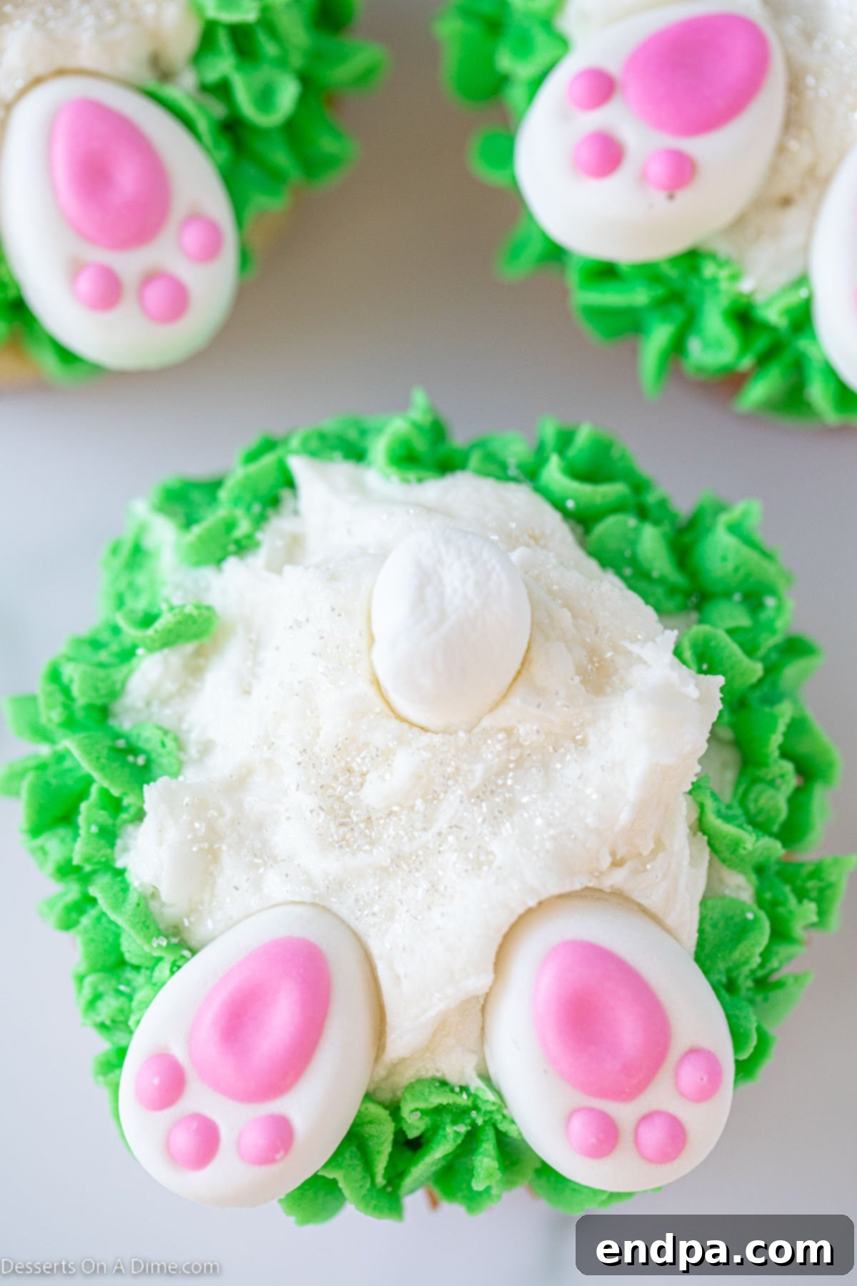 Close-up of a delightful Bunny Butt Cupcake with green frosting and a fluffy marshmallow tail.