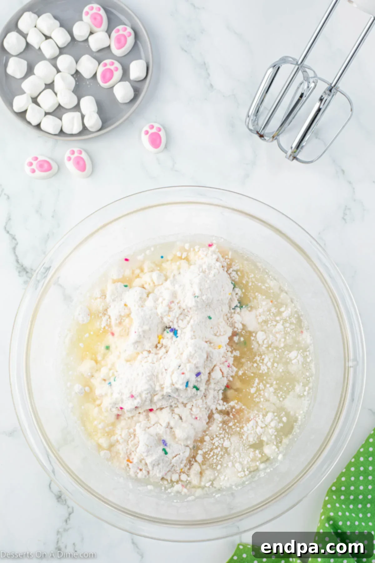 Mixing bowl with vibrant Funfetti cupcake batter being prepared.