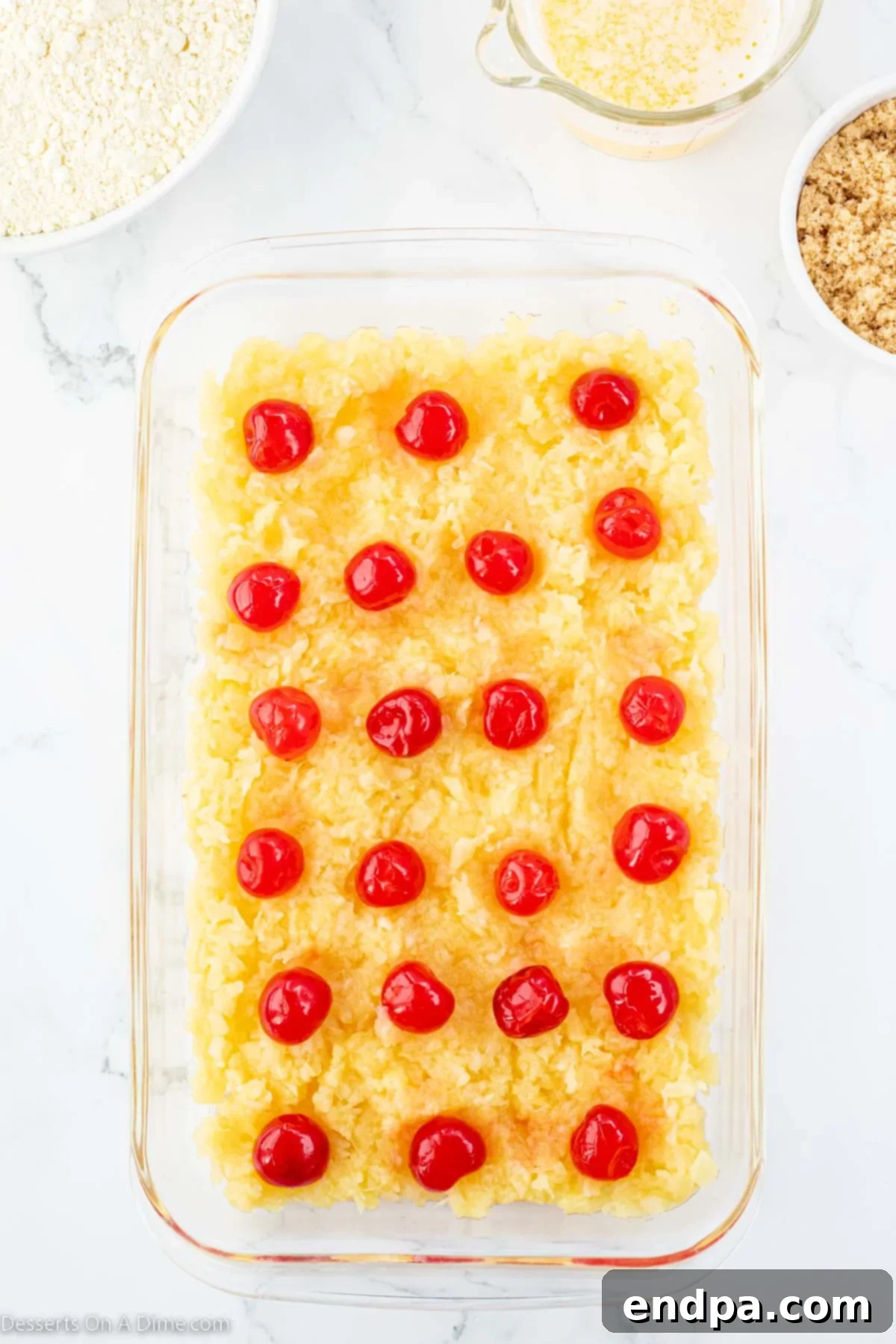 Effortless Pineapple Upside Down Delight 4 Pineapple and cherries layered in baking dish.