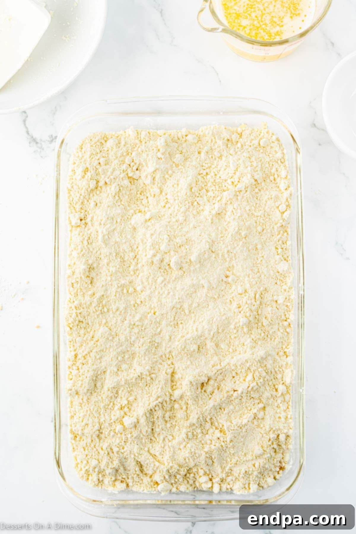 Effortless Pineapple Upside Down Delight 6 Dry cake mix sprinkled on top of fruit.