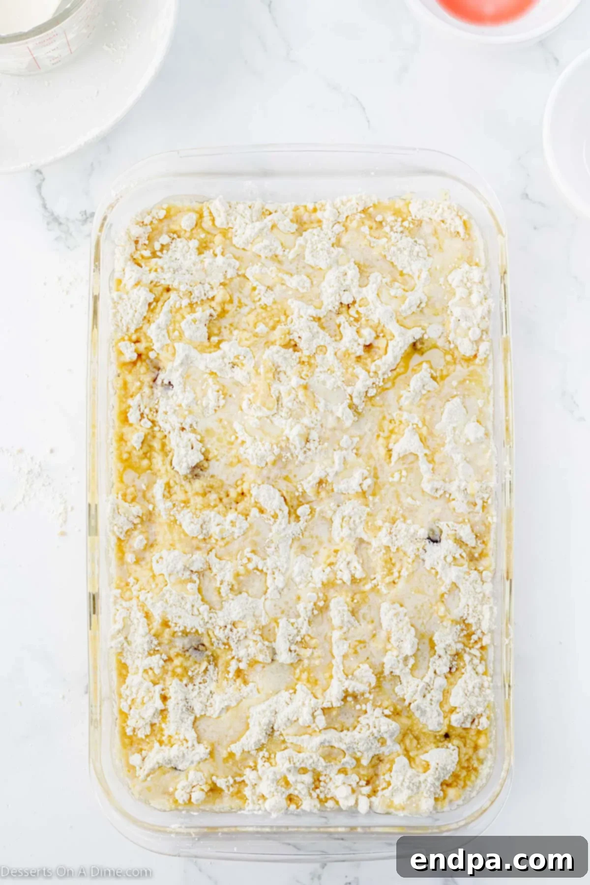 Effortless Pineapple Upside Down Delight 8 Cake batter and butter spread in dish.