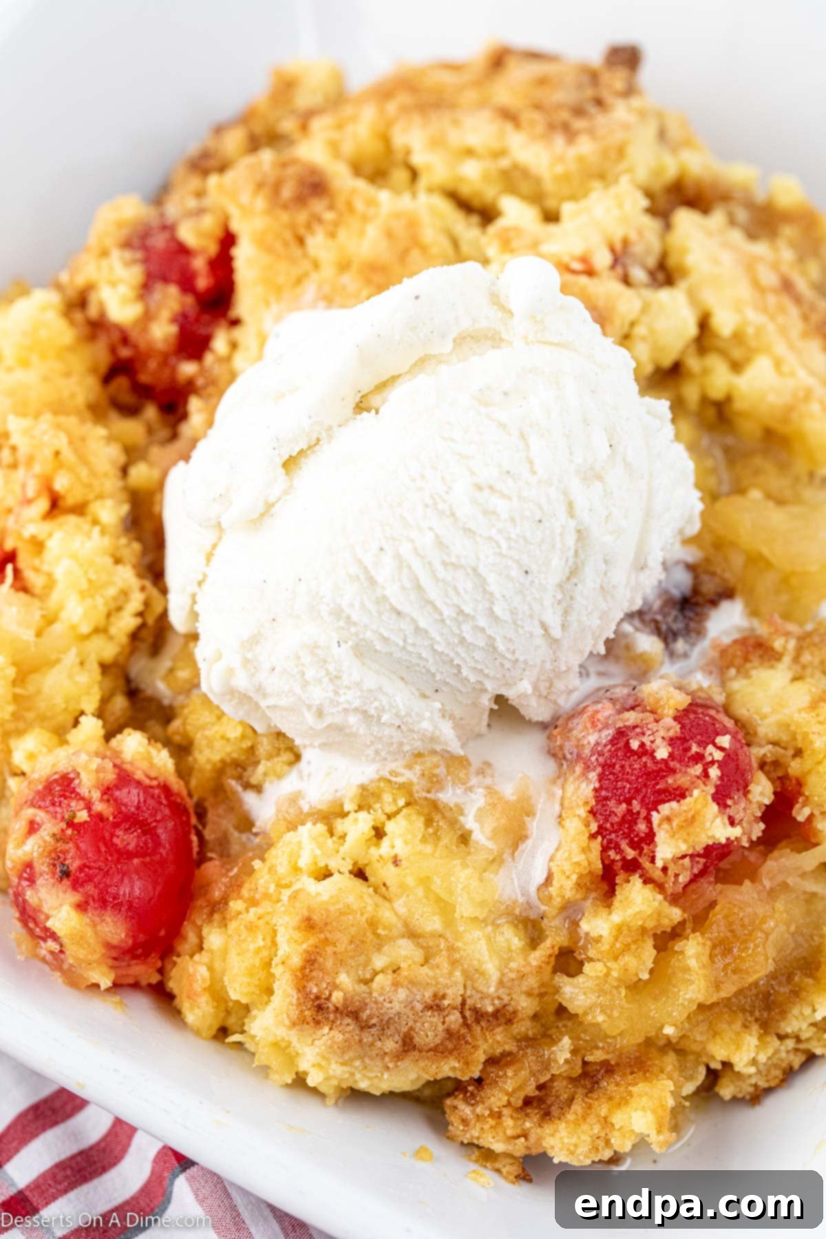 Effortless Pineapple Upside Down Delight 10 Pineapple upside down dump cake in a bowl with ice cream.
