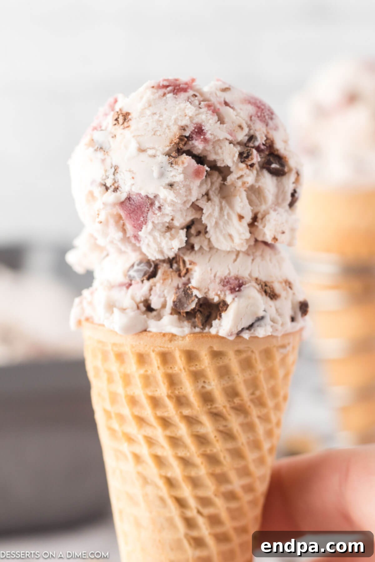 Dark Cherry Chocolate Dream Ice Cream 10 A scoop of Cherry Chocolate Chip Ice Cream in a wafer cone, ready to eat.