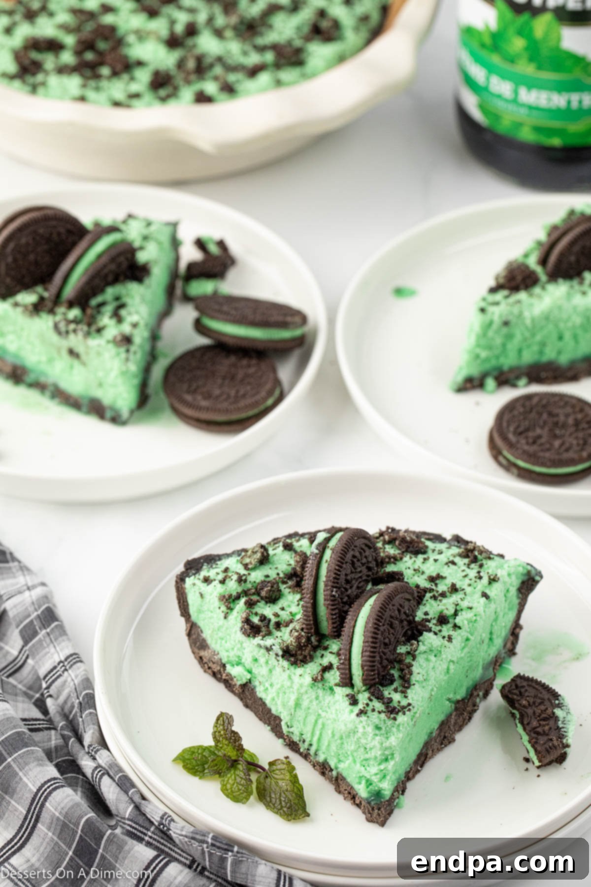 Emerald Mint Delight 2 A perfectly sliced piece of green Grasshopper Pie with an Oreo crust, served on a white plate, highlighting its creamy texture.