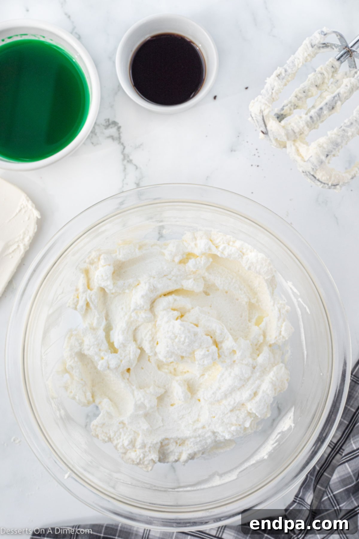 Emerald Mint Delight 6 A large mixing bowl filled with freshly whipped heavy cream, showing stiff peaks, ready for the pie filling.
