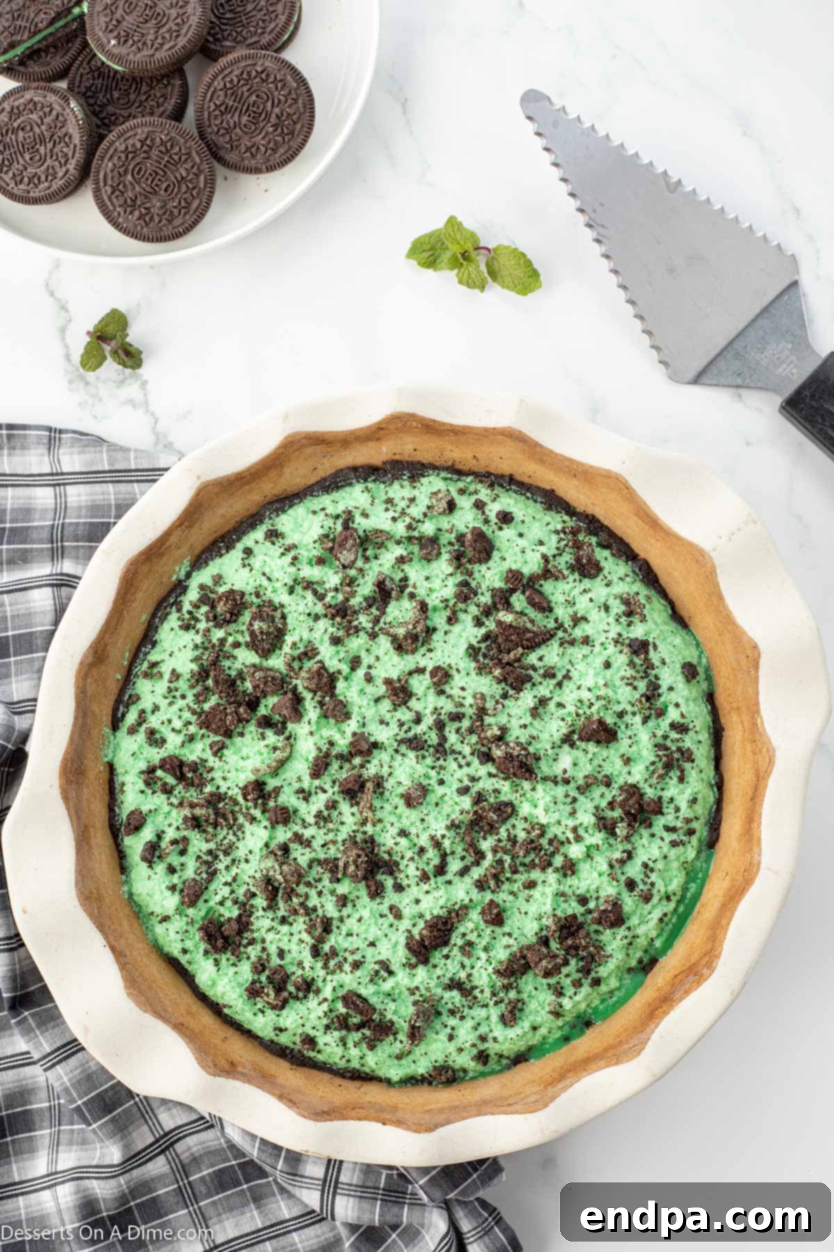 Emerald Mint Delight 9 The finished green Grasshopper Pie filling poured into the Oreo crust, smoothed on top, and garnished with crushed Oreo cookies.