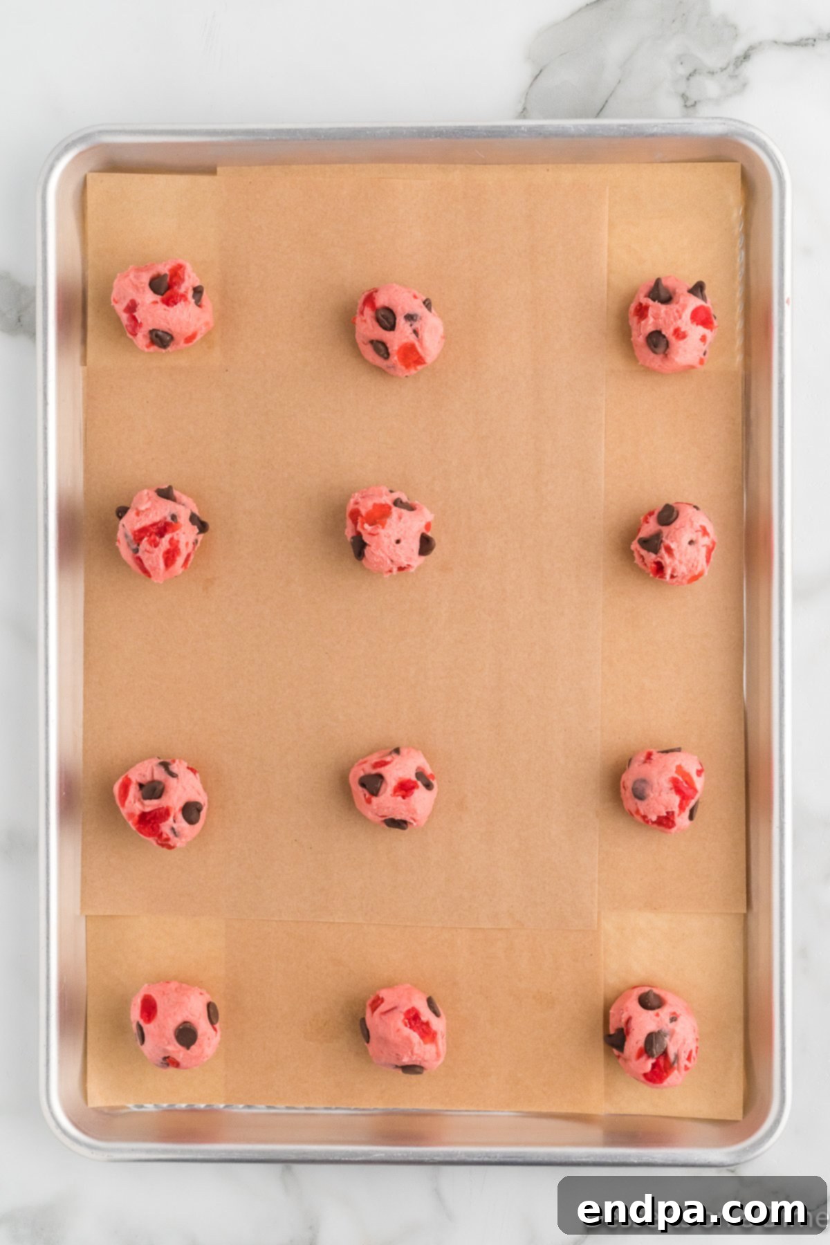 Cookie dough scooped into balls and placed on a baking sheet. 