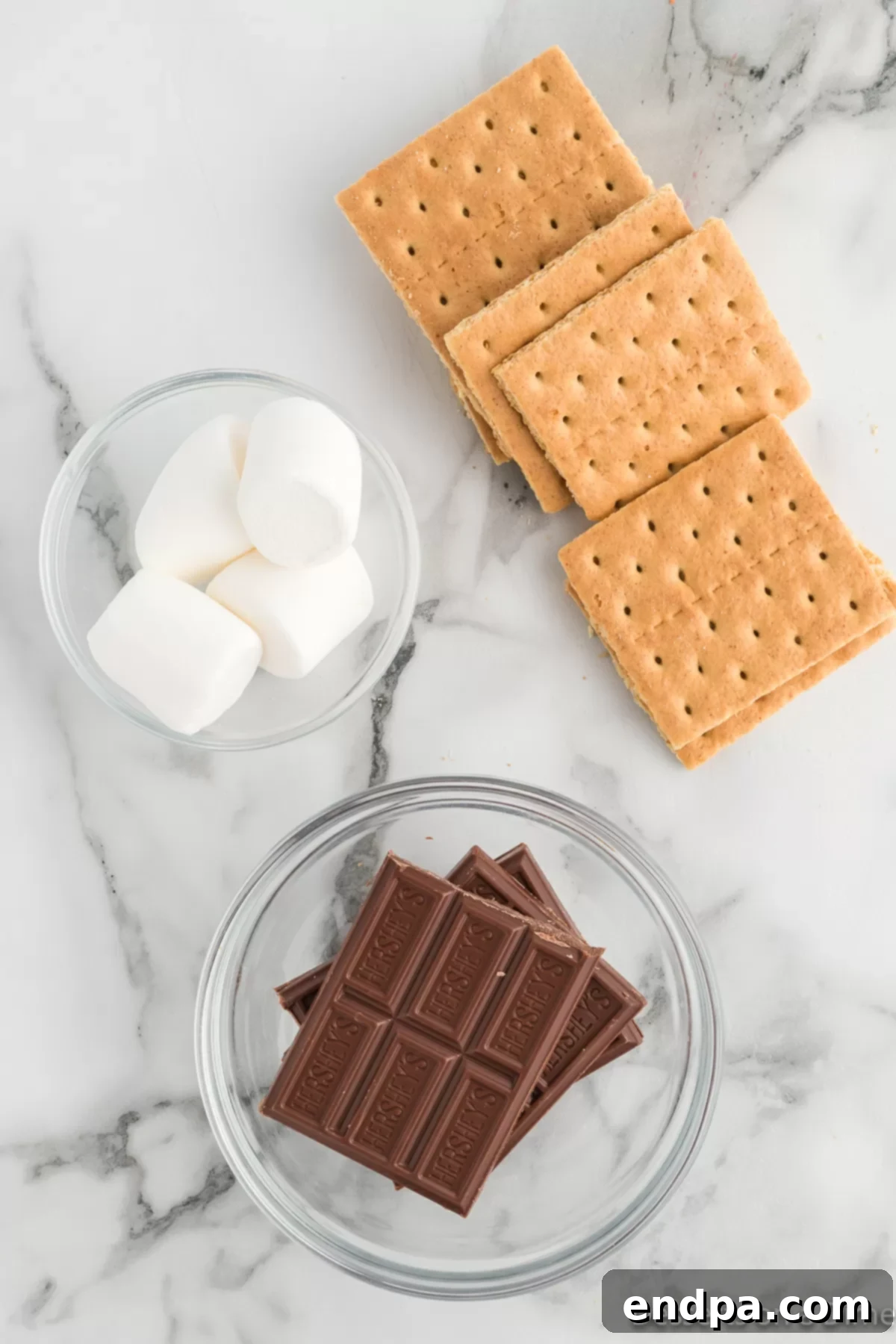 Ingredients for Air fryer s'mores: graham crackers, marshmallows, and chocolate bars laid out.