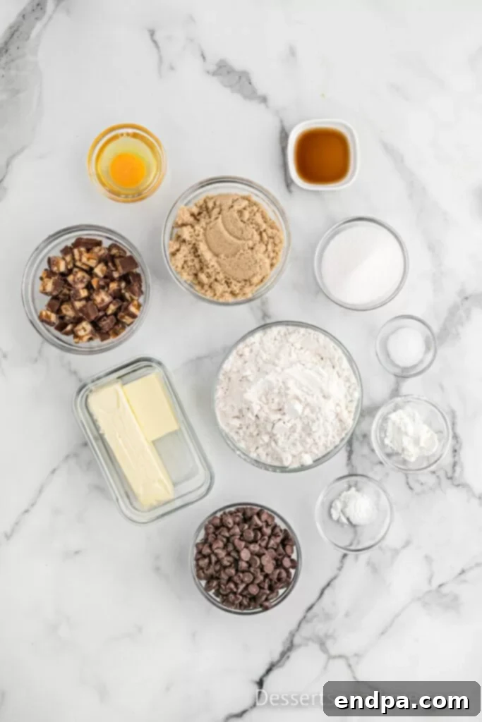 Ultimate Snickers Cookies 3 Ingredients needed - butter, brown sugar, flour, soda, cornstarch, vanilla, egg, salt, chocolate chips, snicker bars