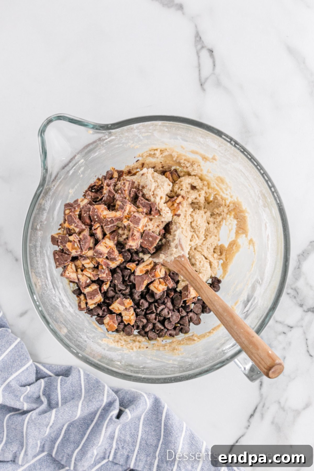Ultimate Snickers Cookies 7 Chocolate Chips folded into bowl.