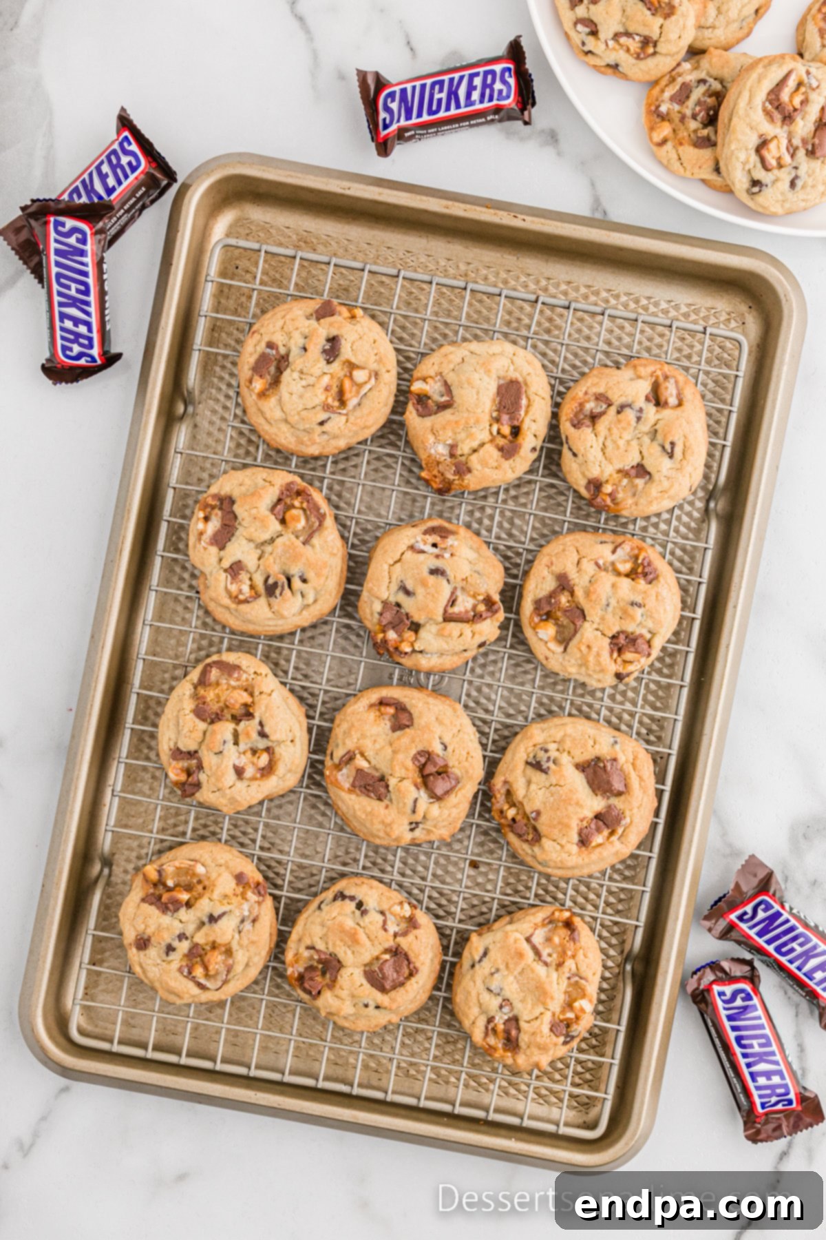 Ultimate Snickers Cookies 9 Cookies on a wire rack.