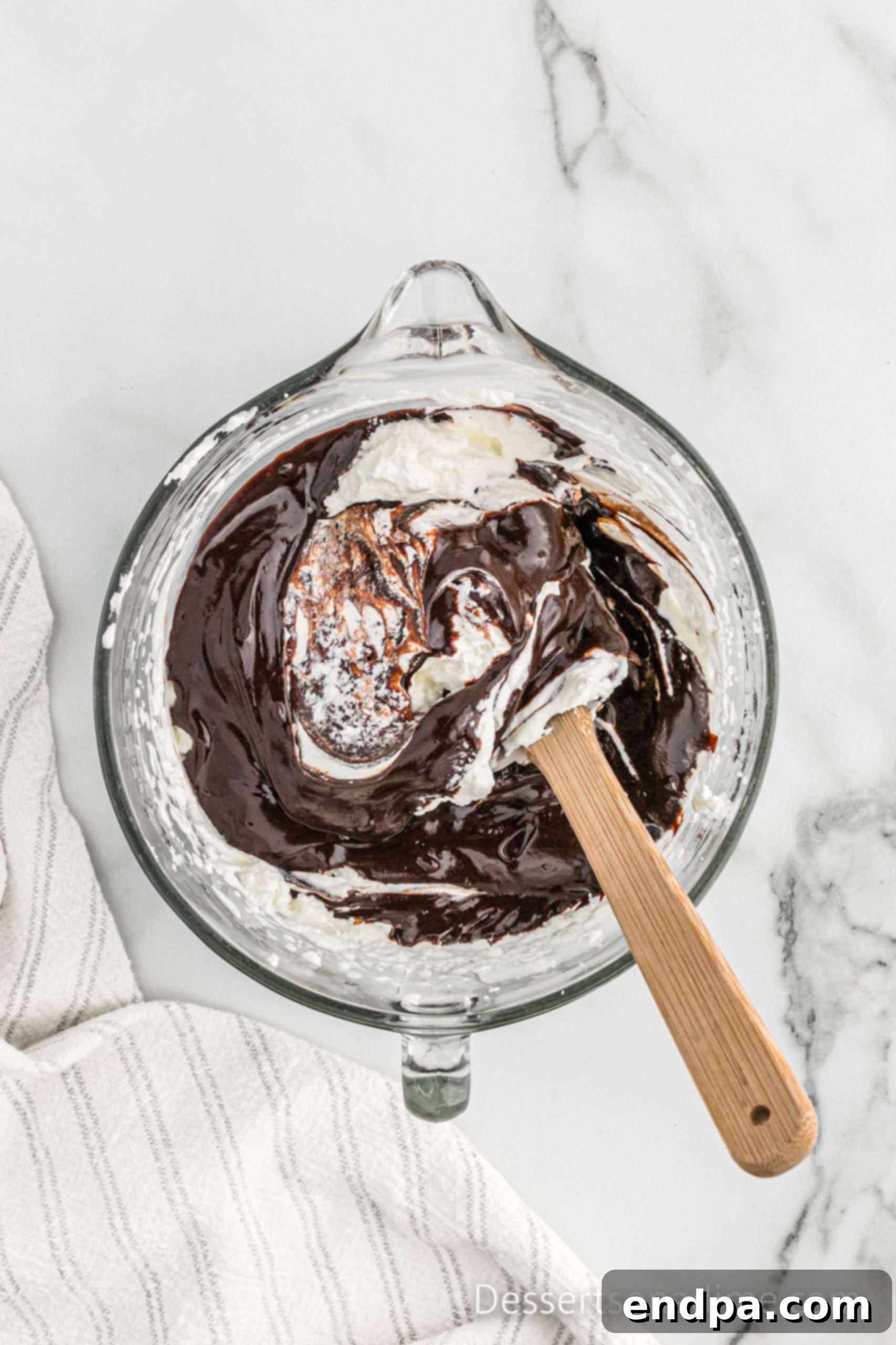 Chocolate mixture being gently folded into whipped cream to make mousse.