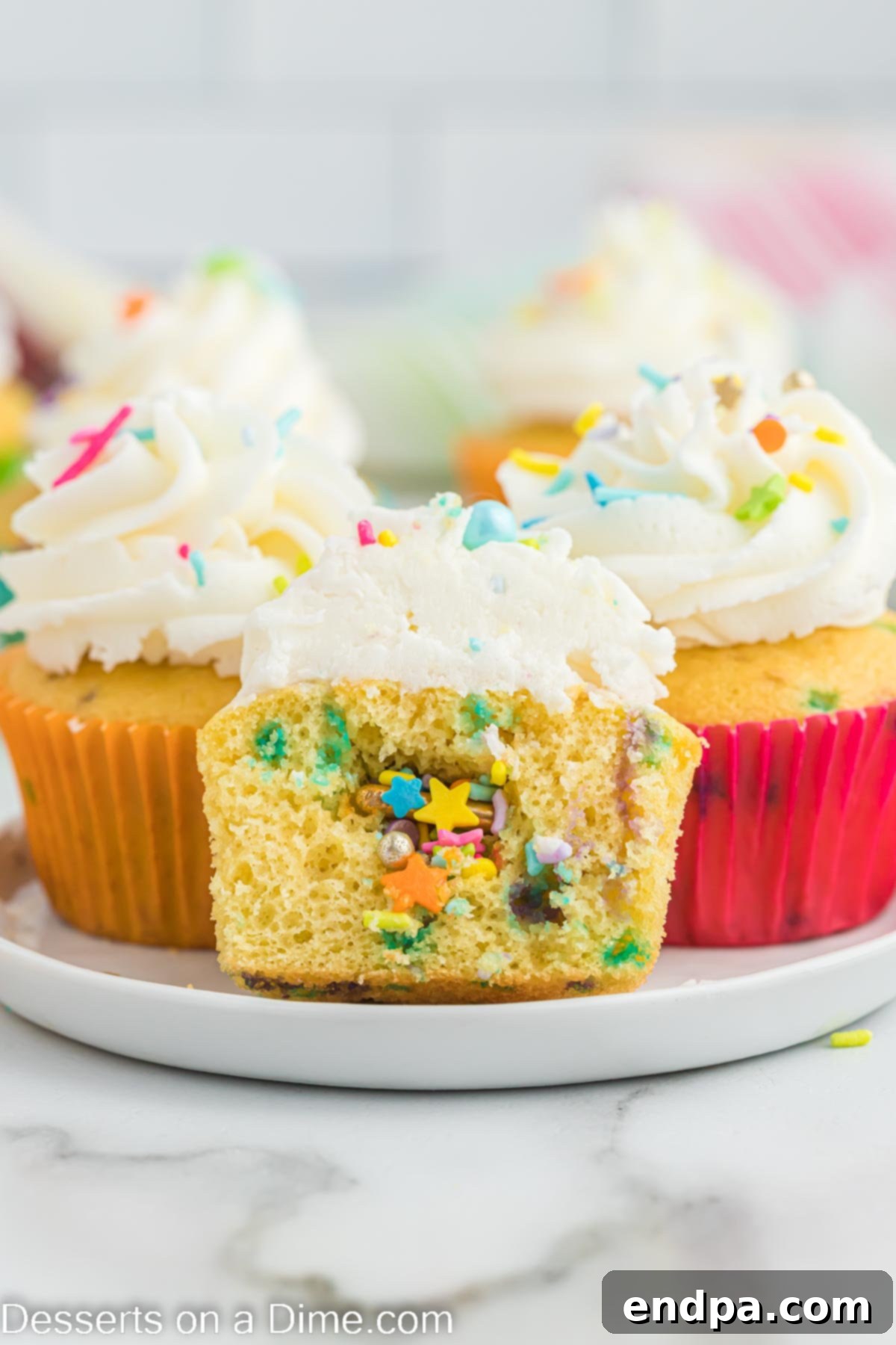 Confetti Cupcakes 2 A plate of colorful Pinata cupcakes, showcasing the sprinkle surprise within.