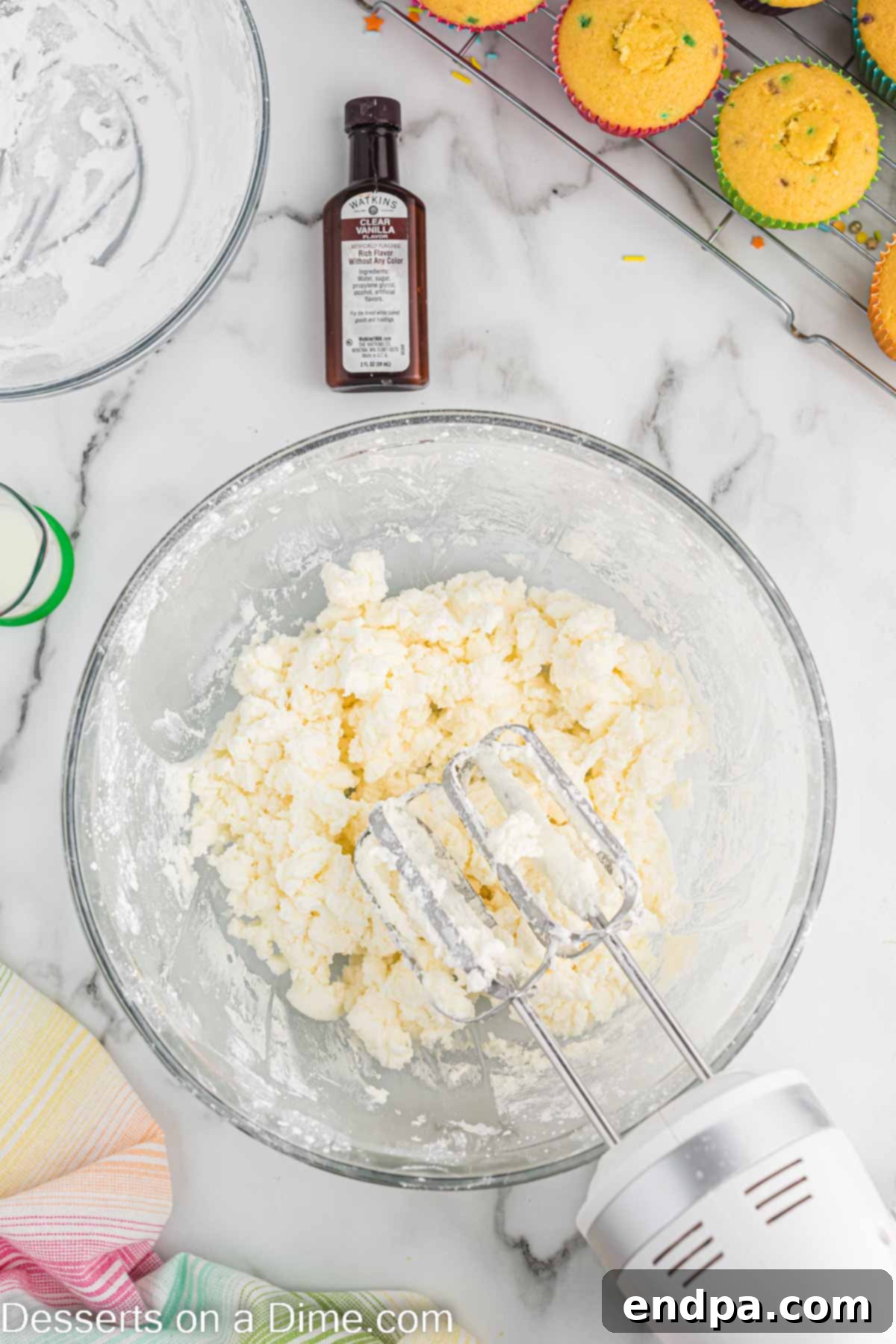 Confetti Cupcakes 7 Powdered sugar being gradually added to the mixing bowl with butter and shortening.