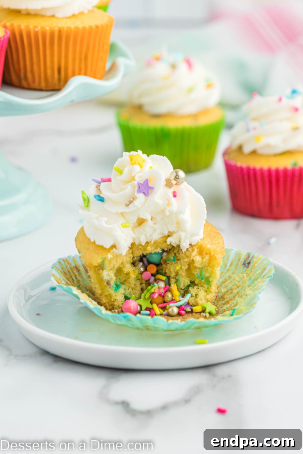 Confetti Cupcakes 10 A close-up of a Pinata cupcake on a plate, showing the fun frosting and sprinkle toppings.