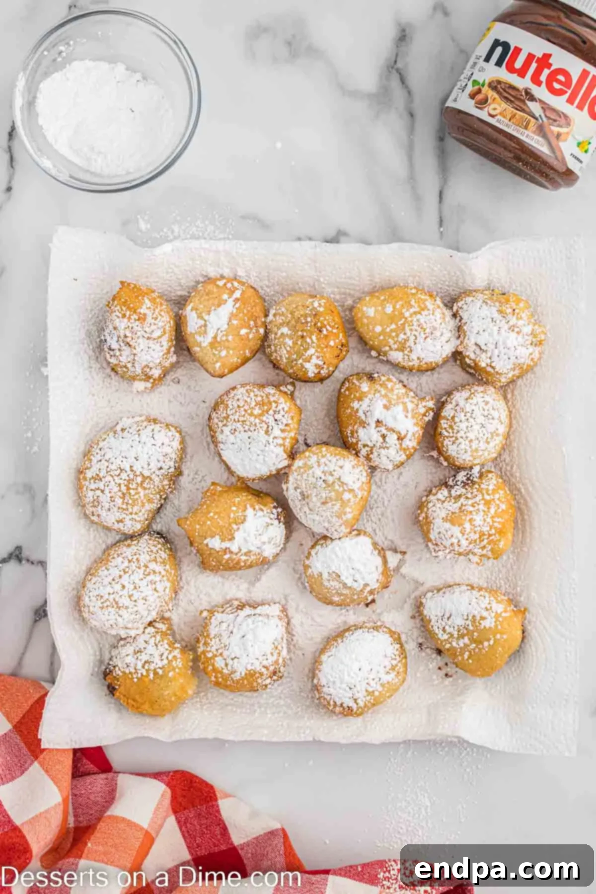 Powdered sugar being sifted over warm Deep Fried Nutella pieces for a sweet finish.