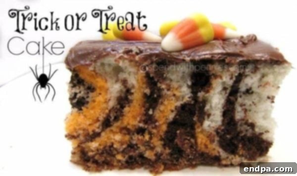 A slice of Trick or Treat Poke Cake with black and orange layers, perfect for Halloween.