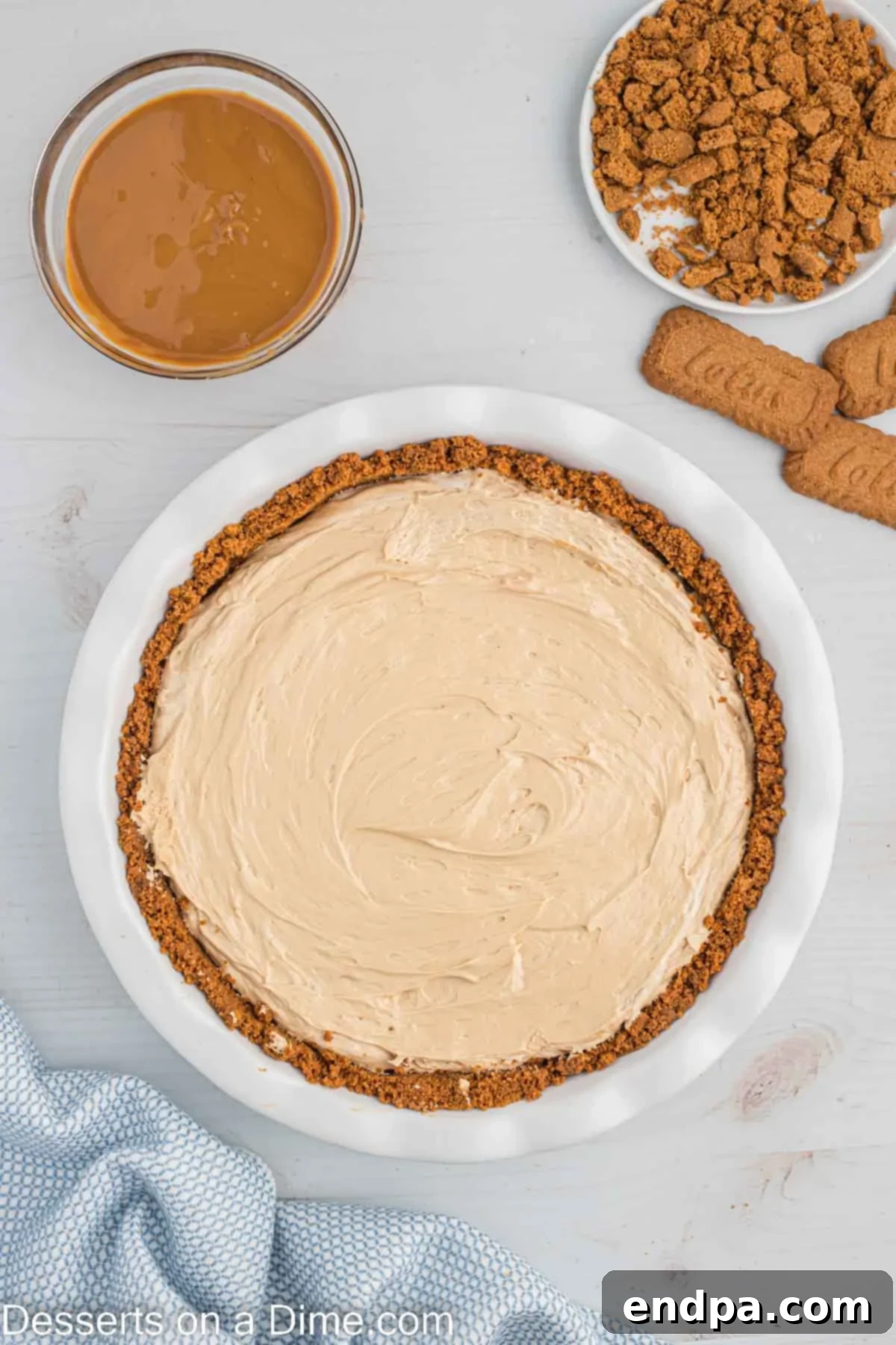 Decadent Cookie Butter Cheesecake 9 Cookie butter cheesecake filling being evenly spread into the chilled biscoff cookie crust in a springform pan.