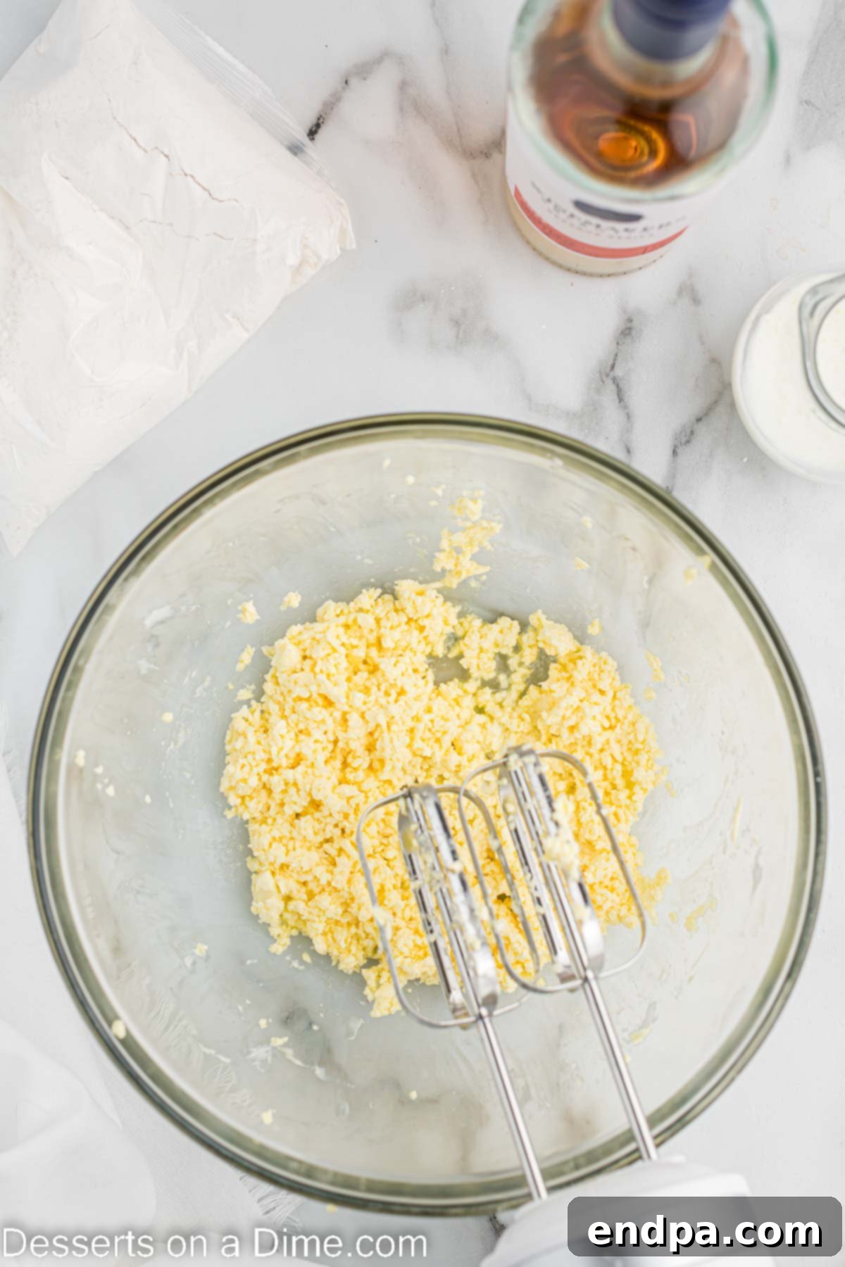 Mixing bowl with softened butter and eggs being whisked.