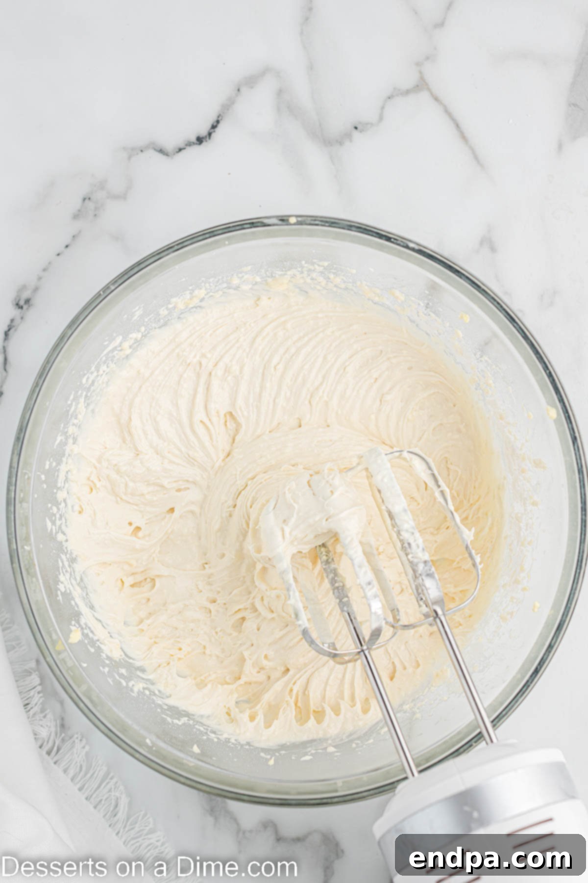 White cake mix, buttermilk, and rosé wine being added to the butter and egg mixture.