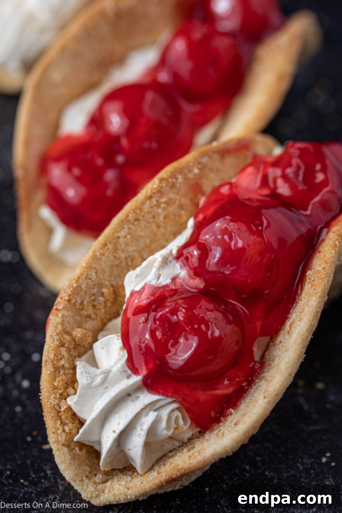 Heavenly Cherry Cheesecake Tacos 2 Cherry Cheesecake Tacos with vibrant cherry pie filling, garnished and ready to serve.