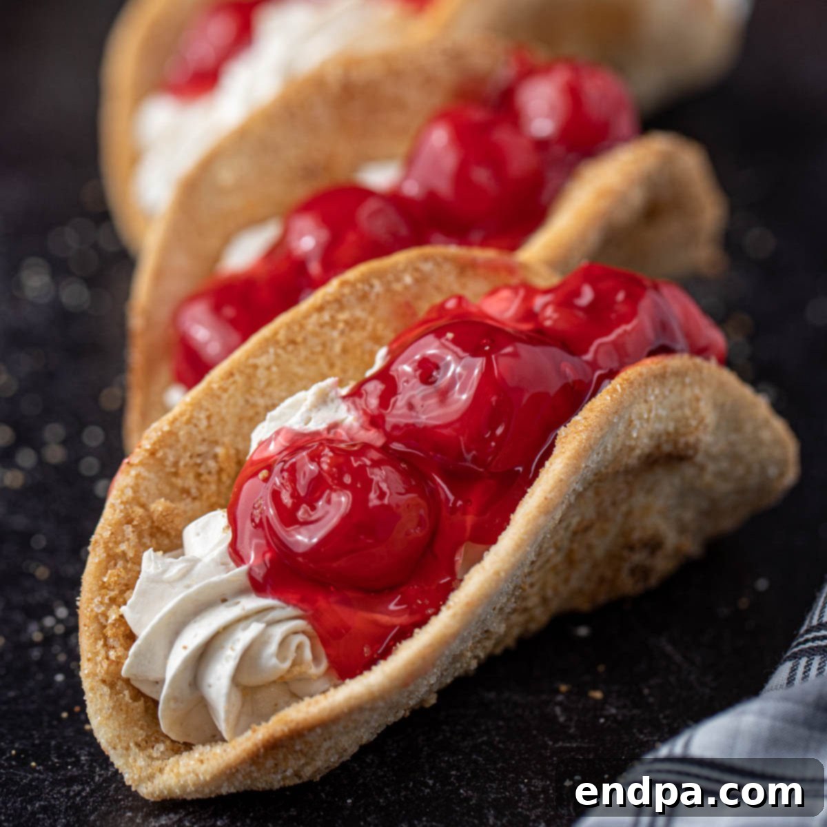 Heavenly Cherry Cheesecake Tacos 11 Detailed image of a finished Cheesecake Taco with cherry pie filling.