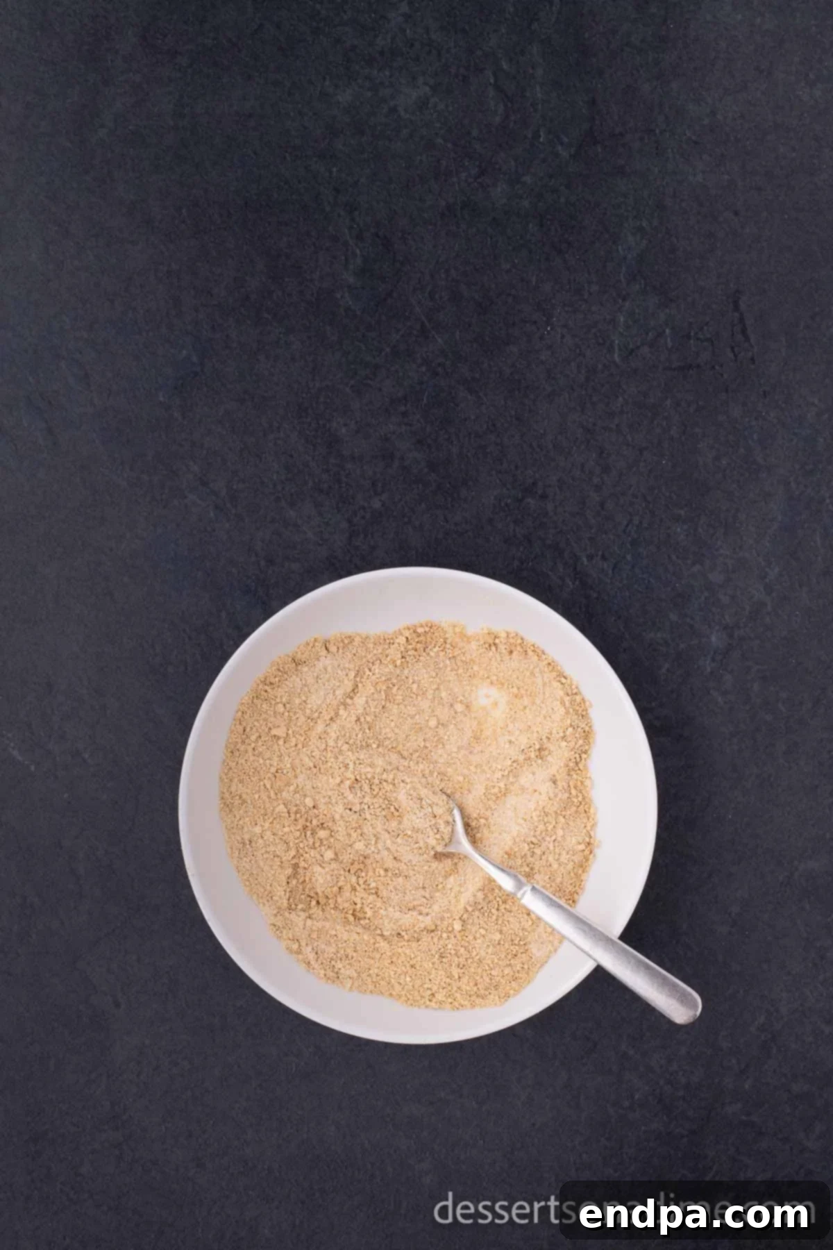 Heavenly Cherry Cheesecake Tacos 4 Bowl containing graham cracker crumbs and granulated sugar, ready for coating.