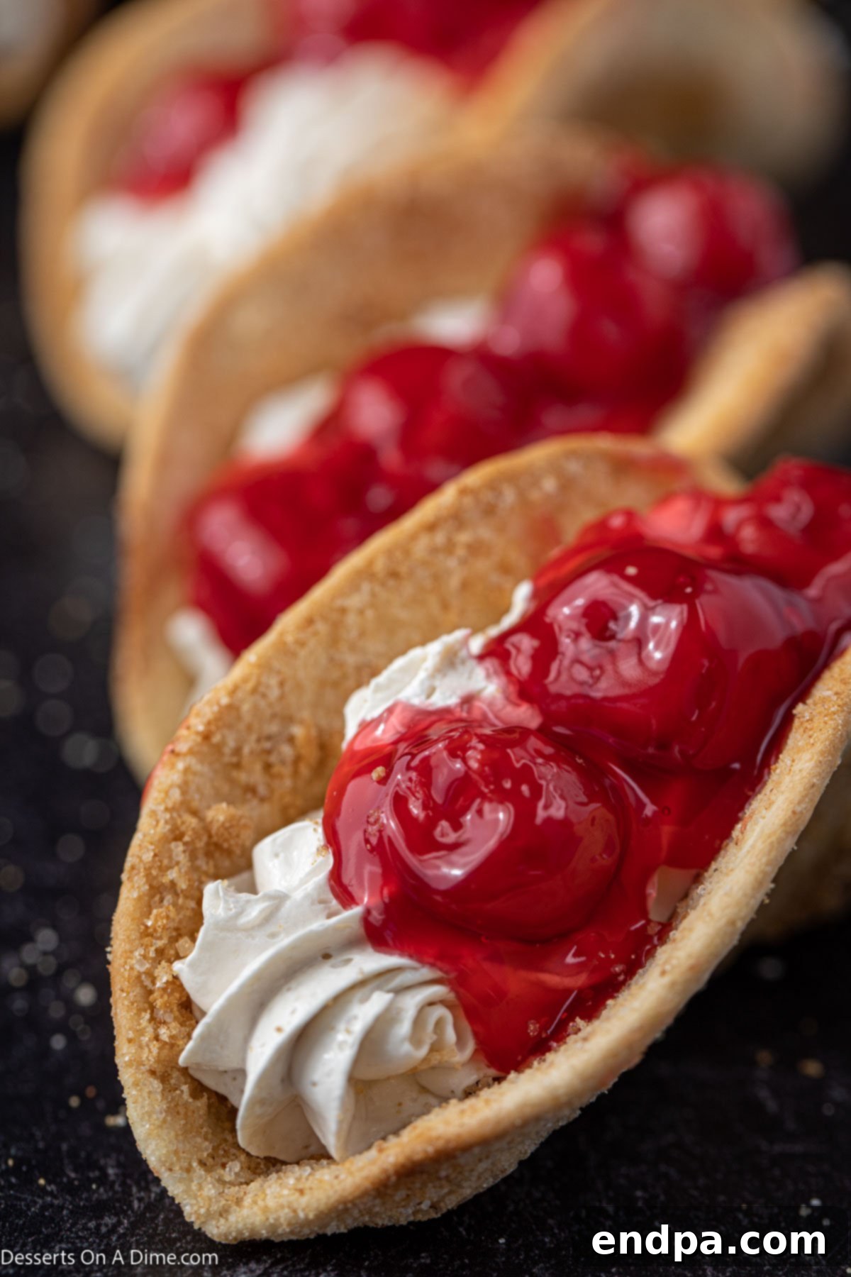 Heavenly Cherry Cheesecake Tacos 10 A delectable platter of Cheesecake Tacos adorned with vibrant cherry pie filling, ready to be enjoyed.