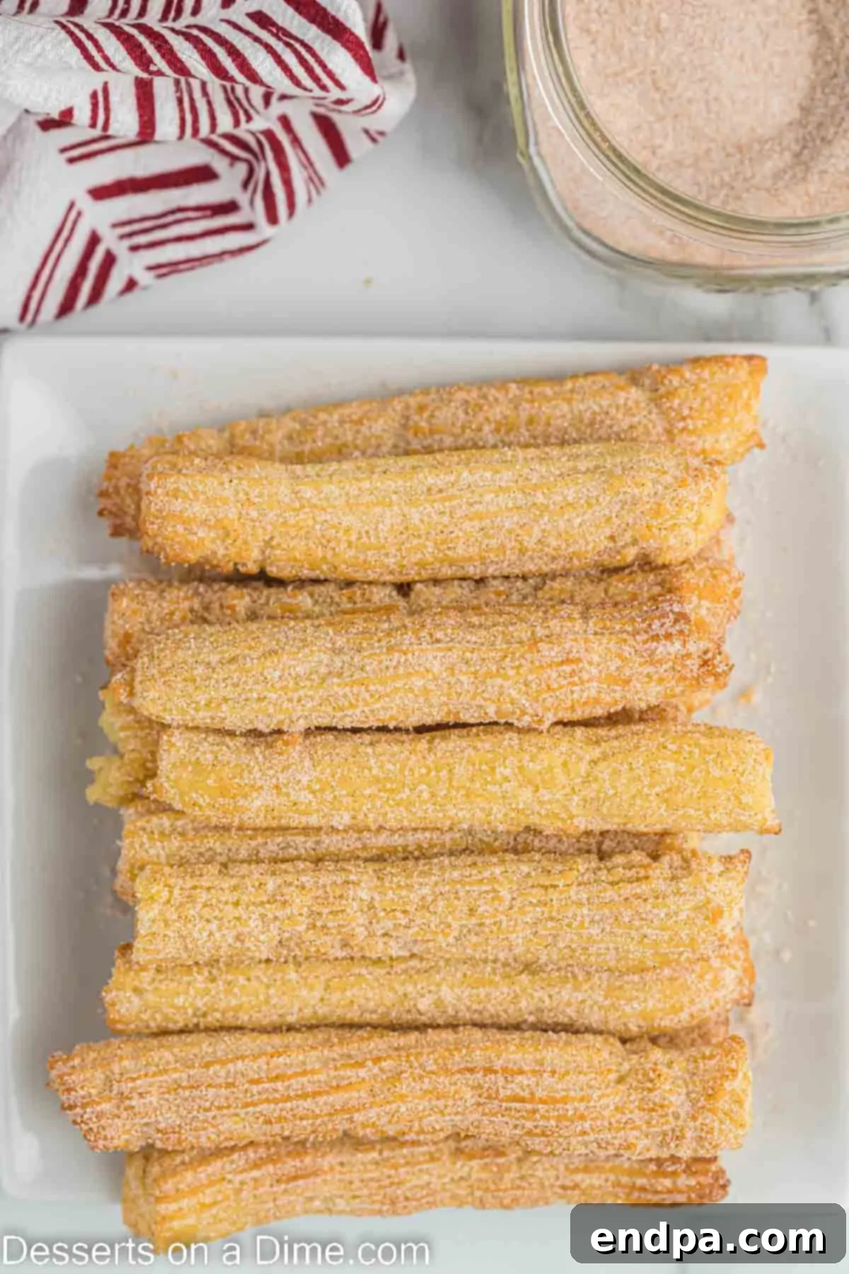Finished air fryer churros arranged on a platter.