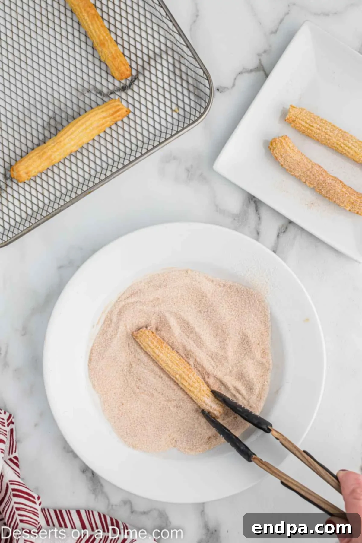 A churro being coated in a bowl of cinnamon and sugar mixture.