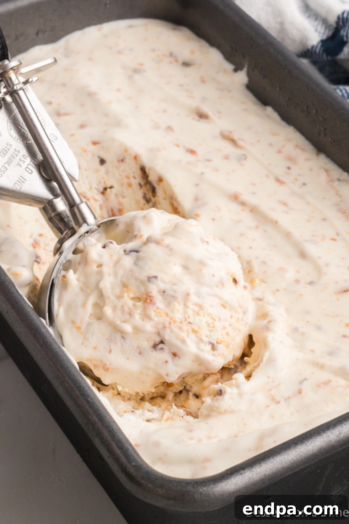 Homemade Butterfinger Crunch Ice Cream 8 Ice cream mixture being spread into a loaf pan before freezing.