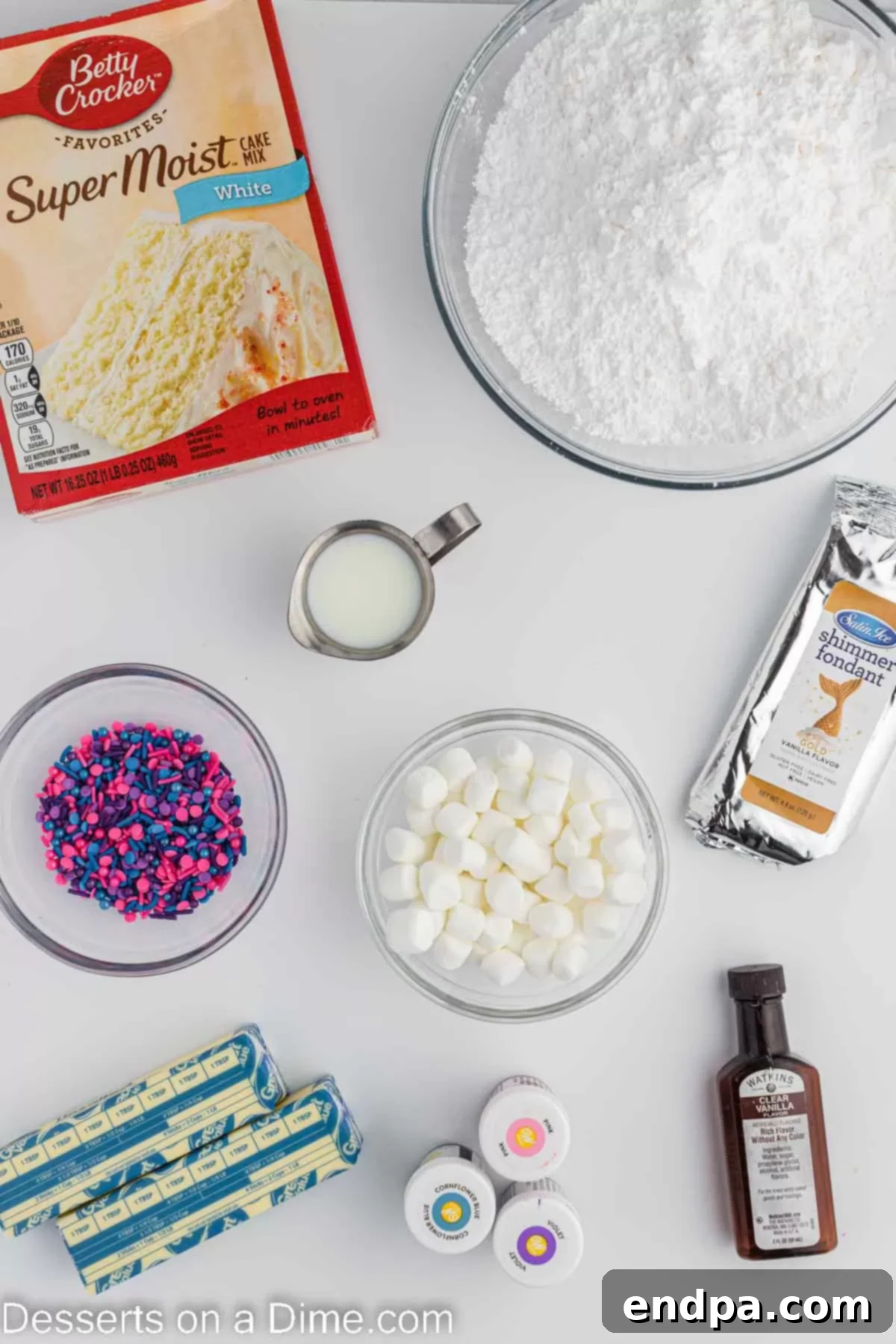 Ingredients for Unicorn cupcakes including cake mix, fondant, sprinkles, butter, powdered sugar, and food coloring.