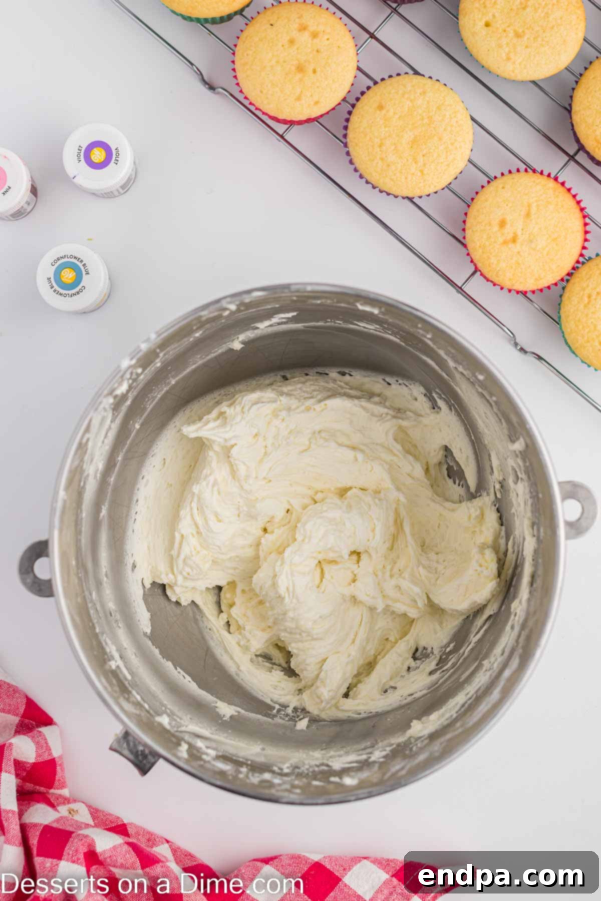 Butter and powdered sugar being combined in a mixing bowl.