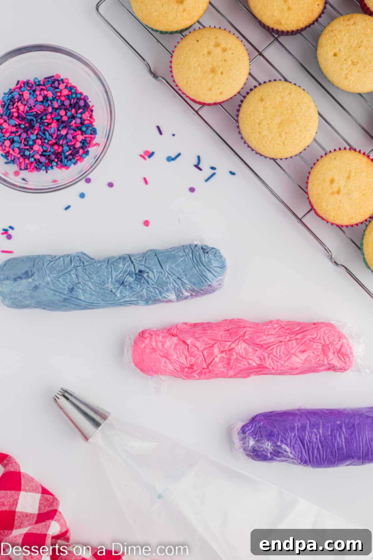 Three logs of colored frosting wrapped in plastic wrap.