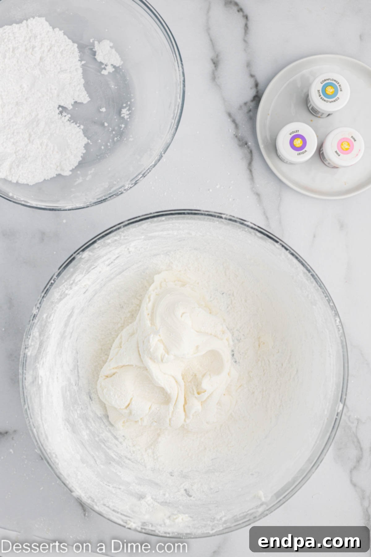 Foolproof Marshmallow Fondant 5 Mixing bowl with melted marshmallow mixture and powdered sugar, gradually combining.