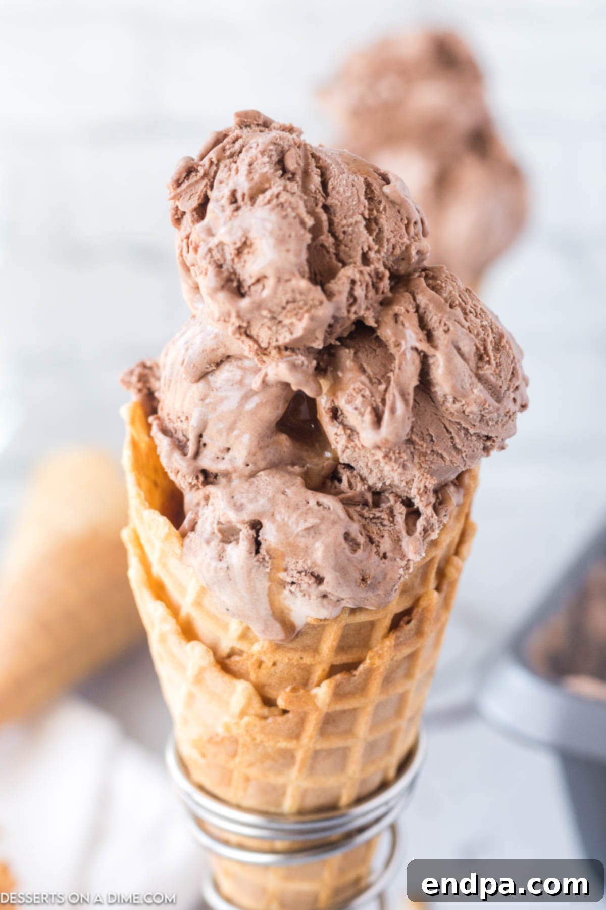 Golden Swirl Chocolate Delight 2 Scoops of creamy no-churn chocolate caramel ice cream served in a waffle cone, ready to be enjoyed.