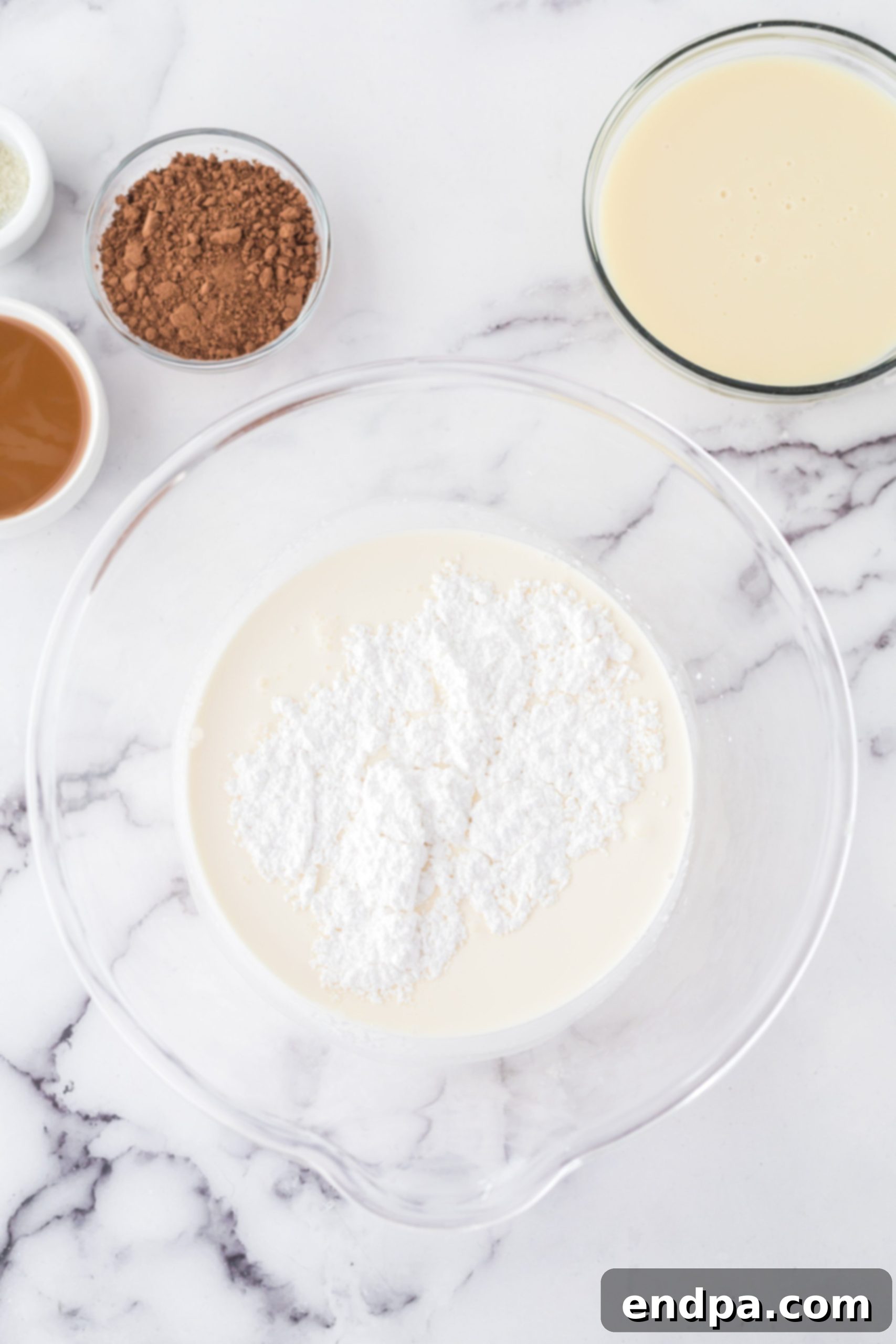 Golden Swirl Chocolate Delight 4 A large mixing bowl containing heavy whipping cream and powdered sugar, being whipped with an electric mixer until stiff peaks form.