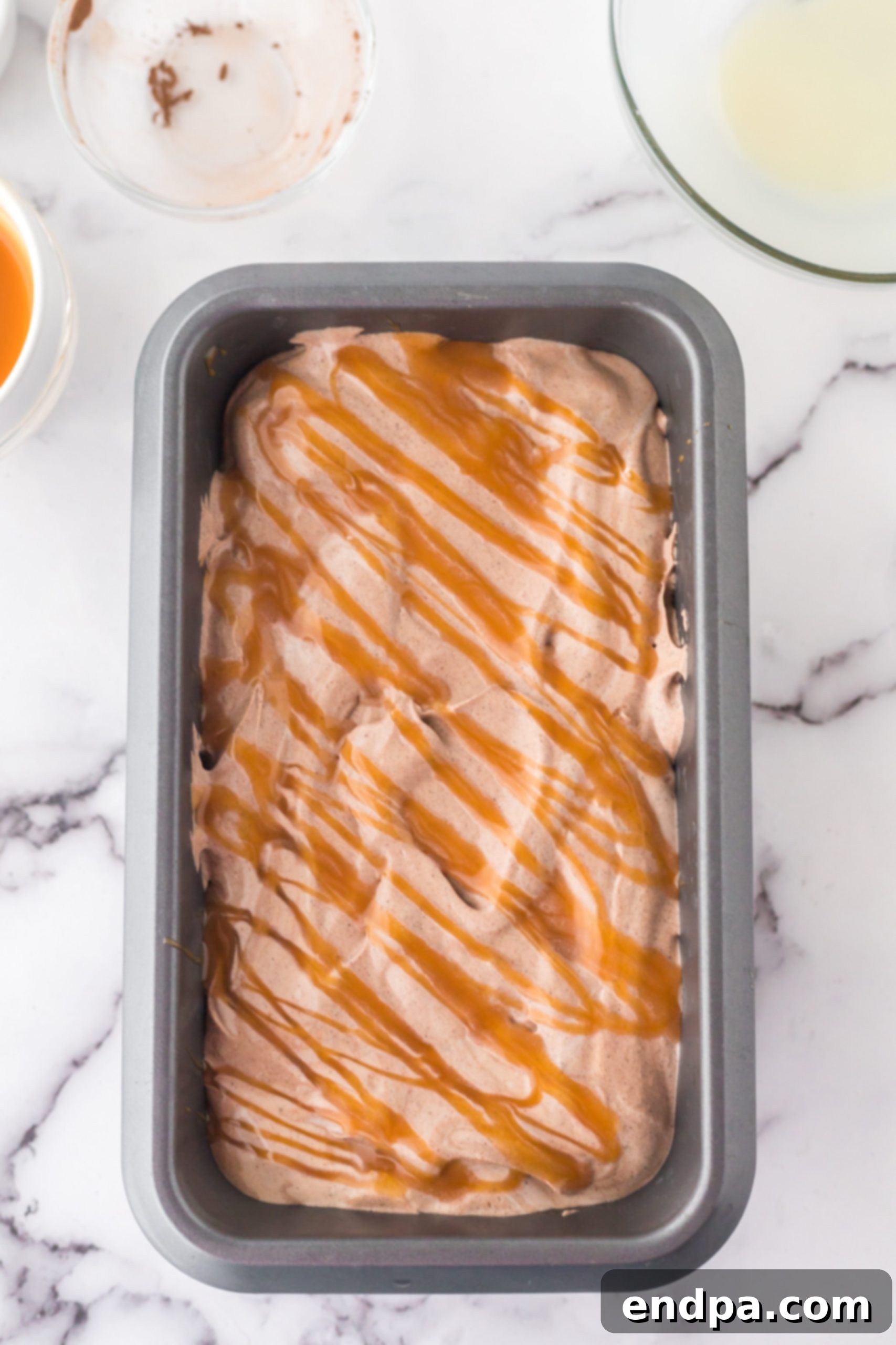 Golden Swirl Chocolate Delight 6 The chocolate caramel ice cream mixture evenly spread into a loaf pan, with a final drizzle of caramel over the top.