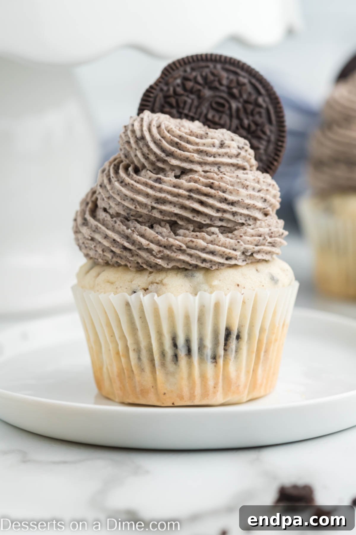 Cookies and Cream Cupcake Heaven 2 Close-up of a frosted Oreo cupcake, topped with a whole Oreo, ready to be enjoyed.